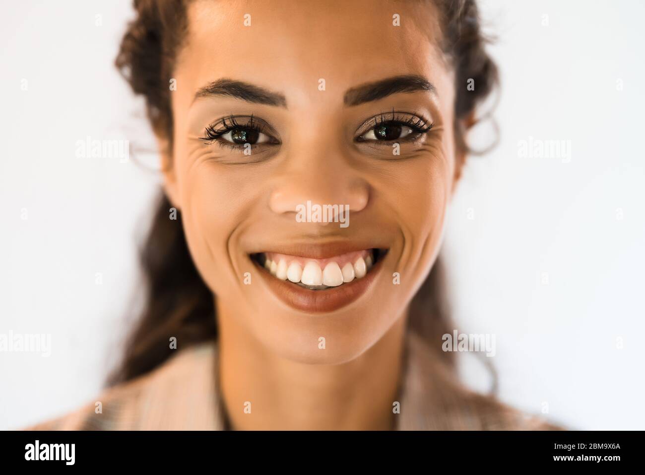 Porträt der schönen afroamerikanischen Frau, die Kamera anschaut und lächelt. Stockfoto
