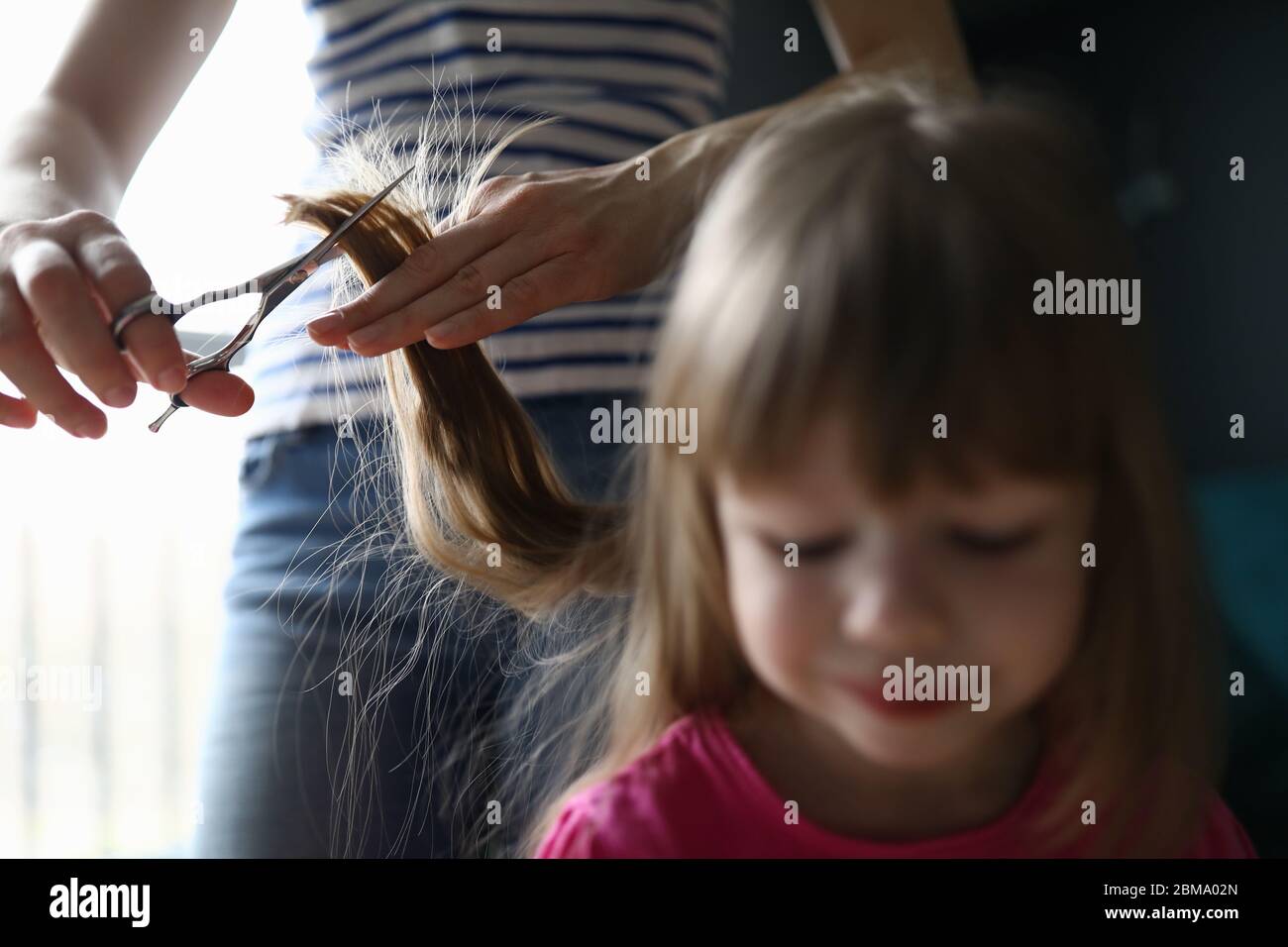 Eltern tut Kleinkind Frisur Stockfoto