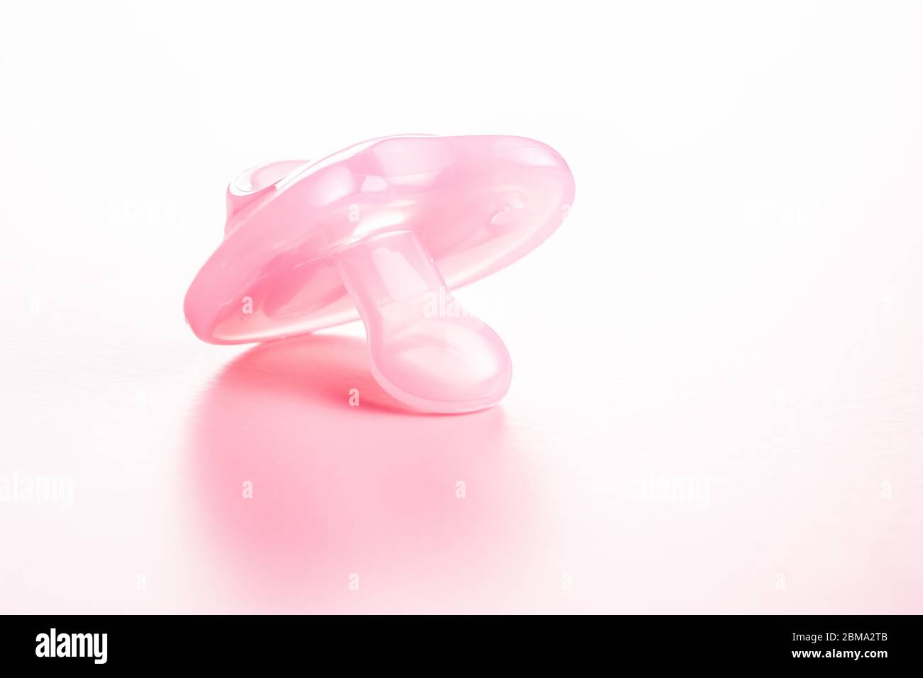 Silikon-Schnuller. Rosa BabySchnuller auf rosa Hintergrund. Stockfoto