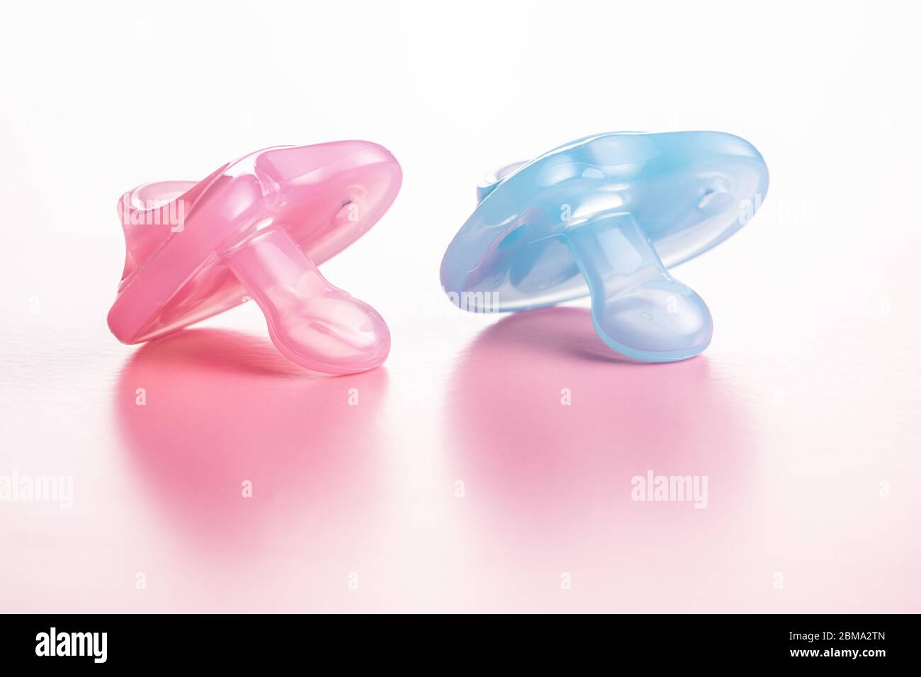 Silikon-Schnuller. Rosa und blau BabySchnuller auf rosa Hintergrund. Stockfoto