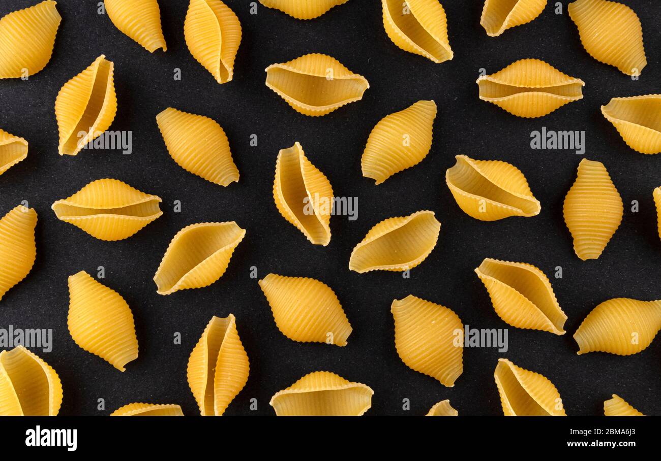 Trockene Schale Pasta Muster auf schwarzem Hintergrund, Draufsicht Stockfoto