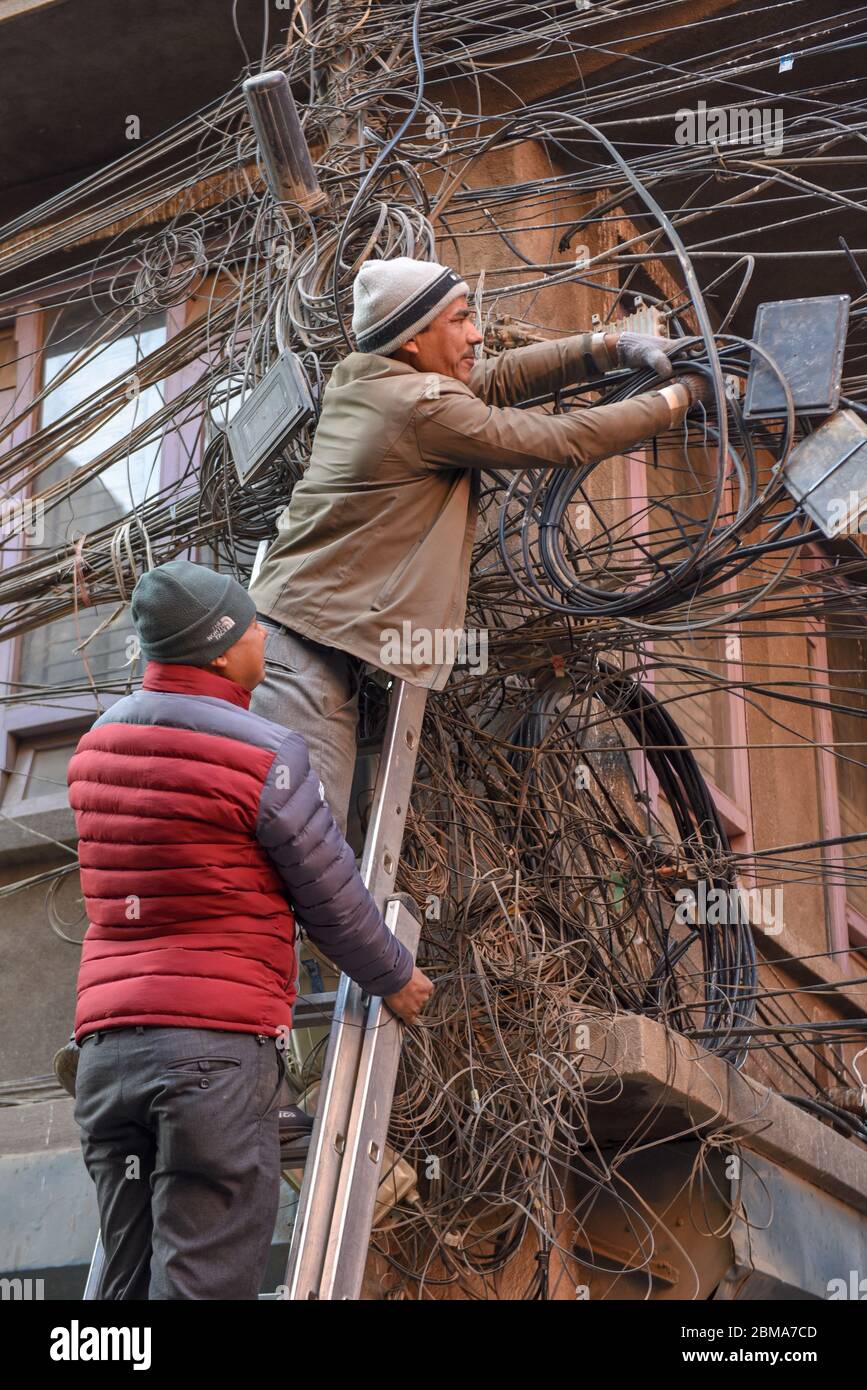 Kathmandu, Nepal - 7. Januar 2020: Arbeiter reparieren eine Vielzahl von verwickelten elektrischen Kabeln in Kathmandu in Nepal Stockfoto
