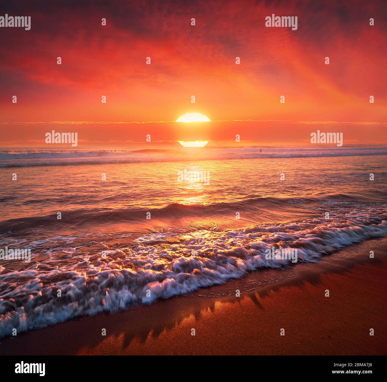 Schöner roter Sonnenuntergang am Strand mit großer Sonne Stockfoto