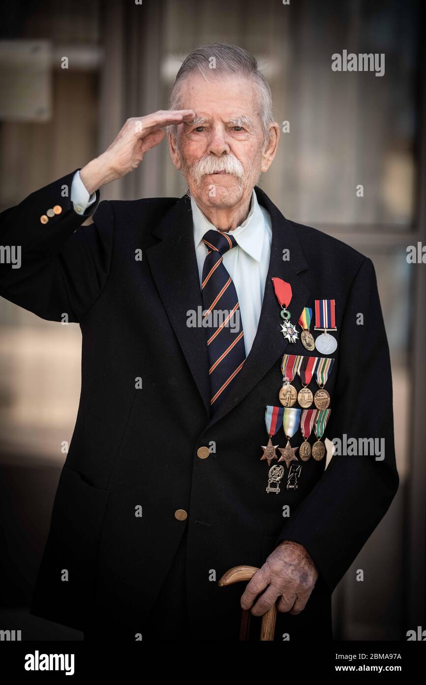 Swansea, Wales, Großbritannien. Mai 2020. Porträt des 96-jährigen Veteranen des Zweiten Weltkriegs begrüßt Clifford Guard am VE Day, vor seinem Wohnkomplex, in dem er allein lebt, während der Blockierung in Großbritannien. Cliff, besser bekannt als "Limey", landete am Omaha Beach, als Teil der 3. Armored Division der amerikanischen Armee und verbrachte 11 Monate an der Spitze des alliierten Vorstoes in Europa nach Deutschland, um an der Befreiung der Konzentrationslager teilzunehmen. Quelle: Robert Melen/Alamy Live News. Stockfoto