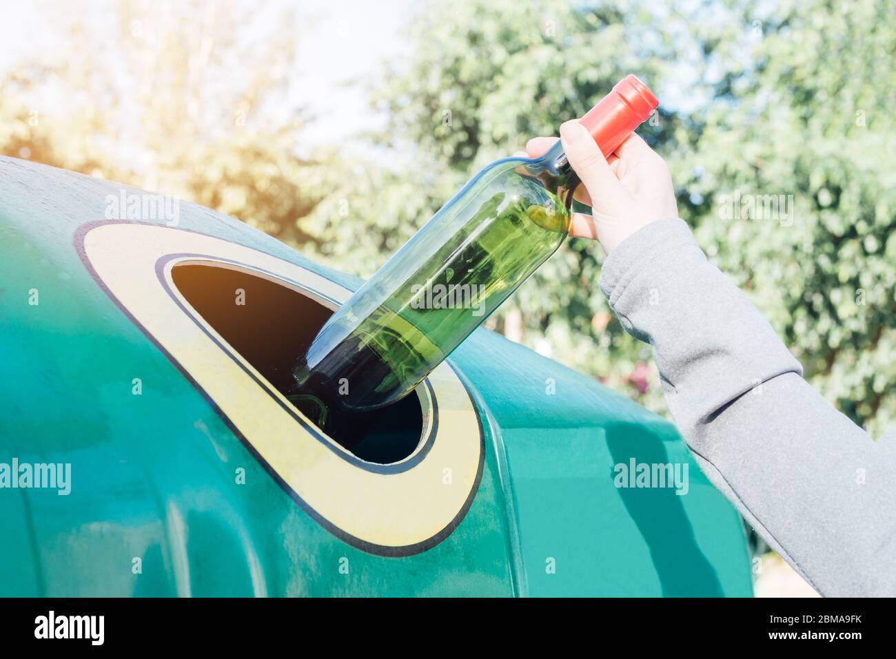 Hand werfen Glasflasche in Recycling-bin Stockfoto