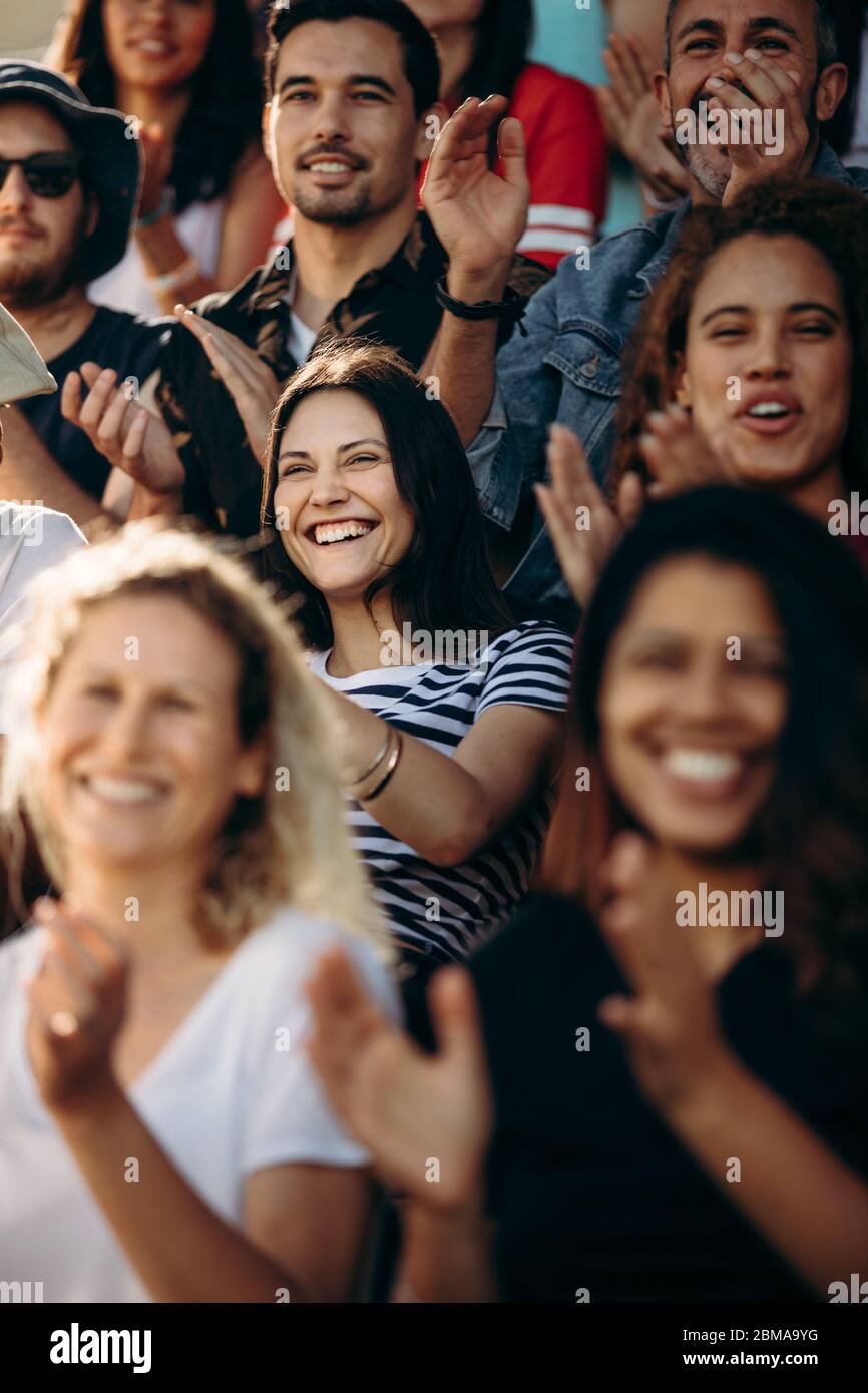 Eine Menge Sportfans jubelten während eines Spiels im Stadion. Frau mit einer Gruppe von Freunden beim Sportspielen feiern, wenn ihr Team ein Tor erzielt. Stockfoto