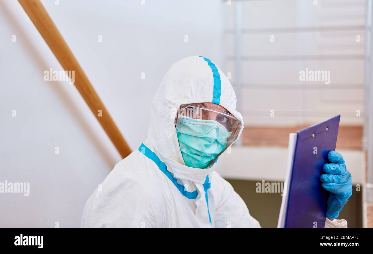 Pflegepersonal im Pflegeheim in Schutzkleidung mit Besucherliste für Coronavirus-Pandemie Stockfoto