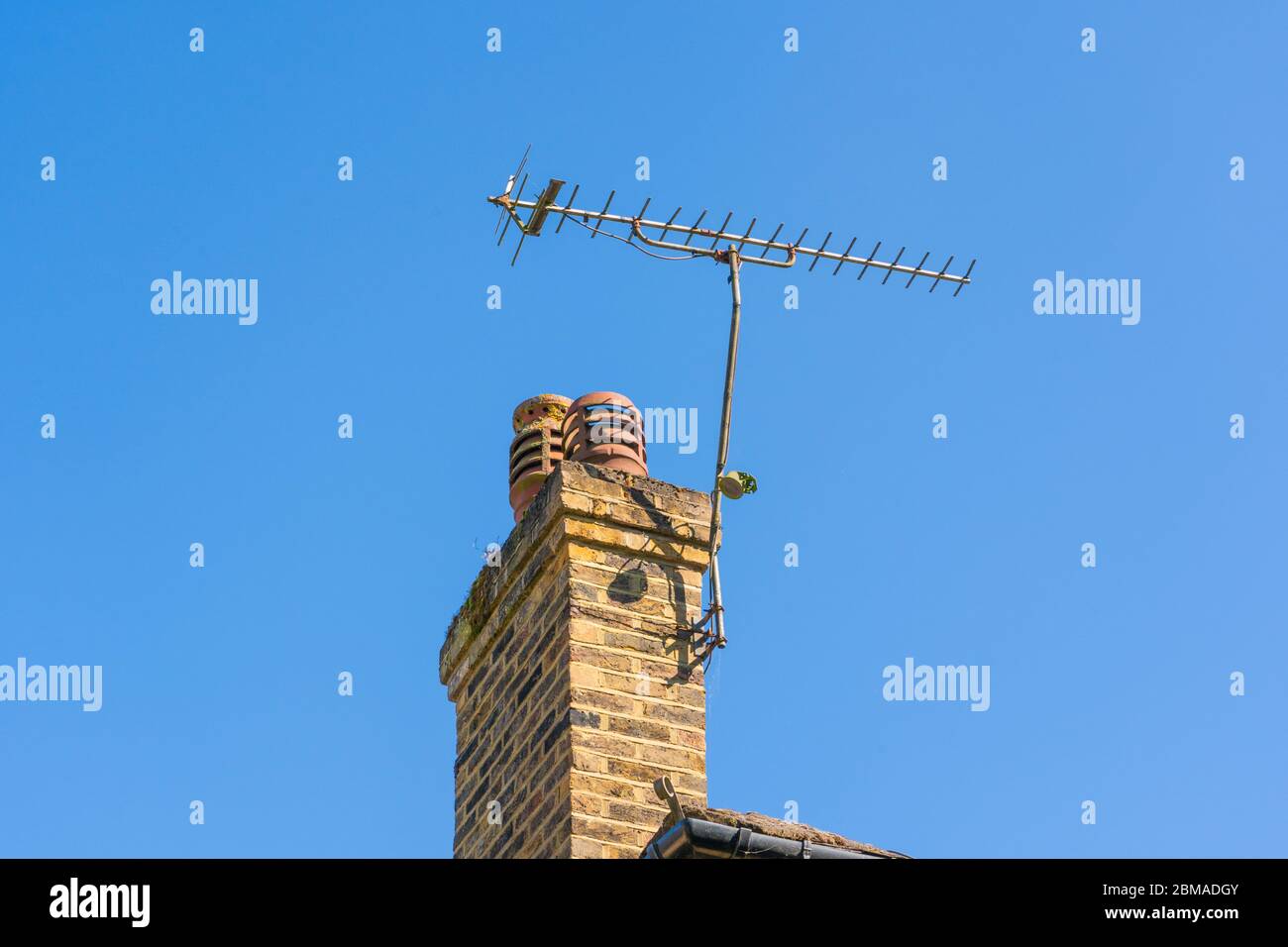 Eine Fernsehantenne auf einem Kamin gegen einen blauen Himmel. Hertfordshire. GROSSBRITANNIEN Stockfoto