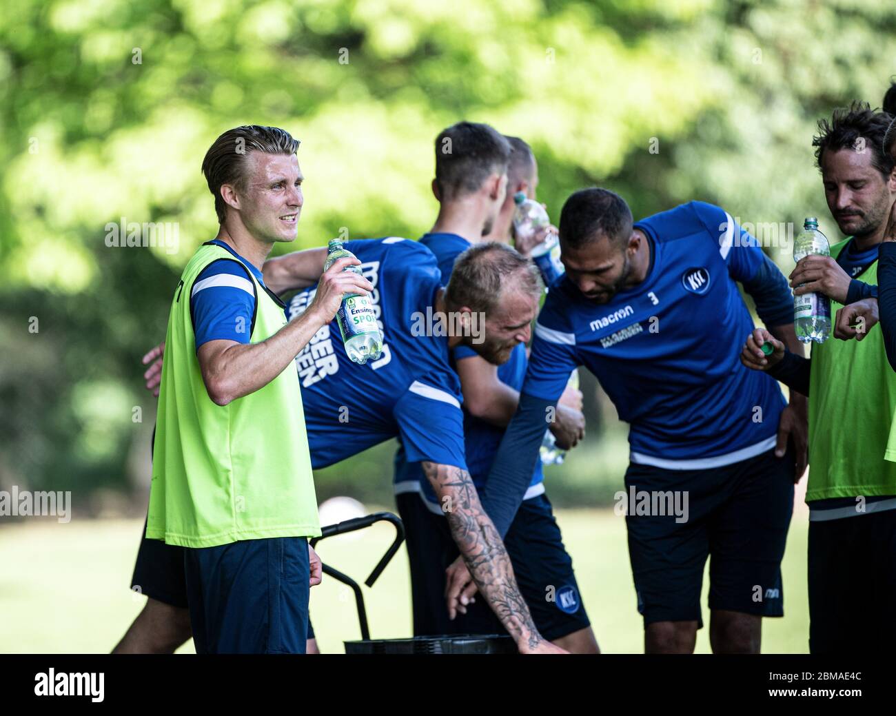 Karlsruhe, Deutschland. Mai 2020. Marco Thiede (KSC) trinkt während des Trainings aus einer Wasserflasche. Zurück: Philipp Hofmann (KSC), Daniel Gordon (KSC) und Anton Fink (KSC). Der Karlsruher SC startet heute mit der Teamschulung. GES/Football/2. Bundesliga: Training des Karlsruher SC während der Corona-Krise, 8. Mai 2020 Fußball: 2. Liga: Mannschaftstraining, Training des Karlsruher SC während der Corona-Krise, 08. Mai 2020 Quelle: dpa/Alamy Live News Stockfoto
