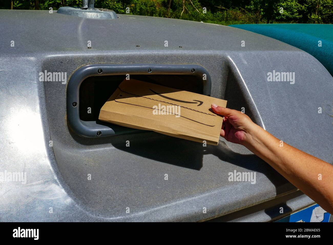 Amazon Kartonverpackung wird in großen Kunststoff-Recycling-Behälter in der Region Ariege in Südfrankreich platziert Stockfoto