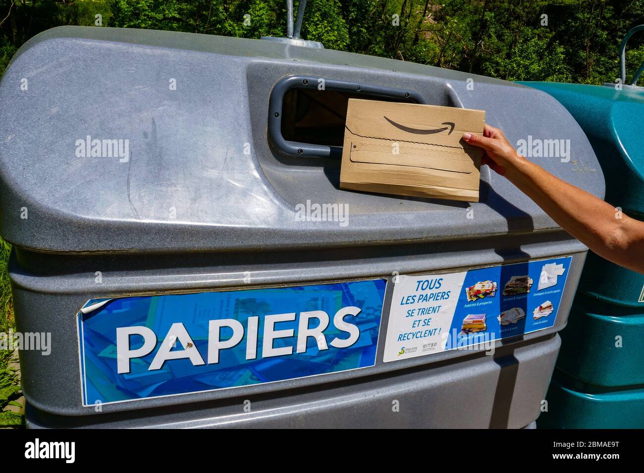 Amazon Kartonverpackung wird in großen Kunststoff-Recycling-Behälter in der Region Ariege in Südfrankreich platziert Stockfoto
