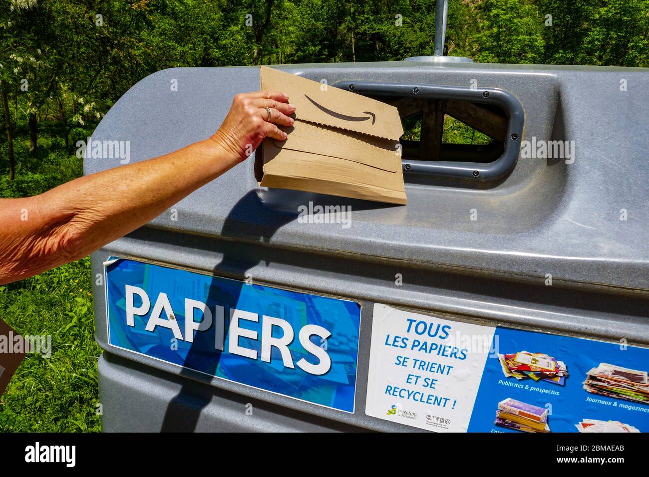 Amazon Kartonverpackung wird in großen Kunststoff-Recycling-Behälter in der Region Ariege in Südfrankreich platziert Stockfoto