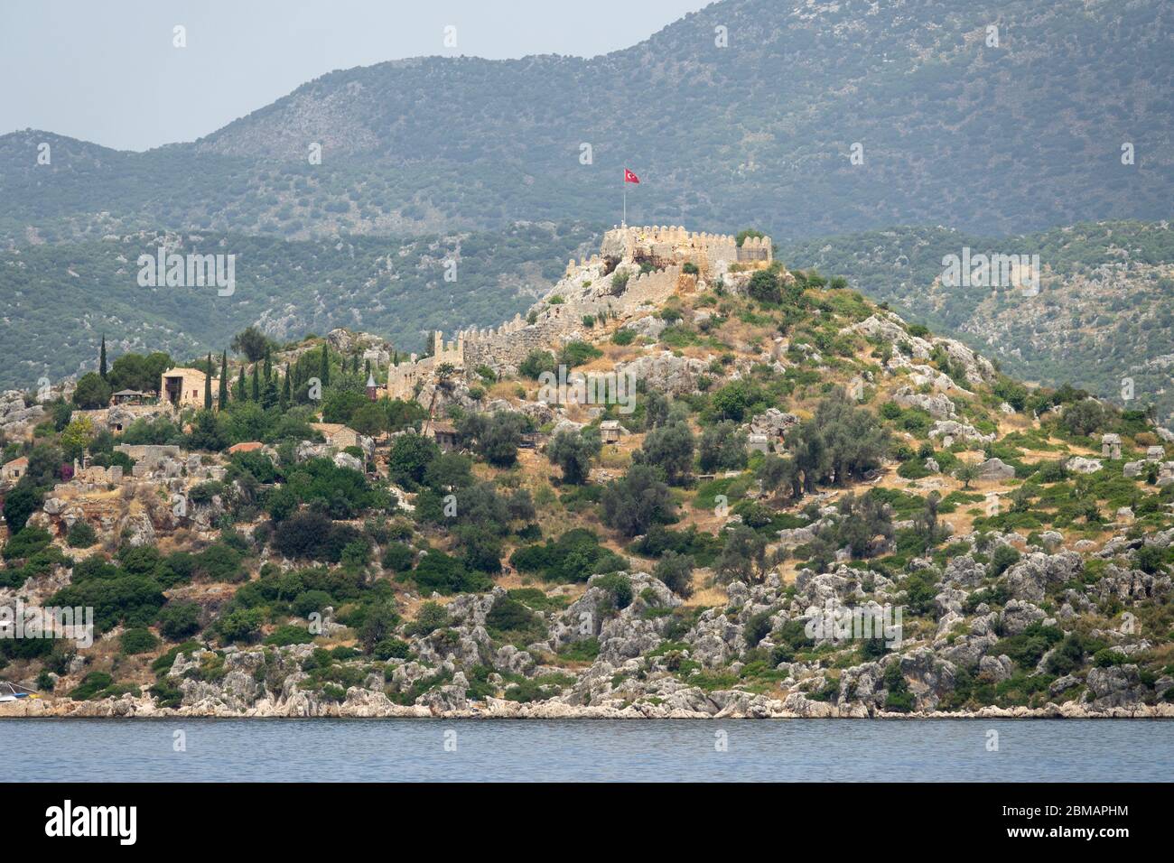 Kalekoy Dorf mit Steinhäusern und Burg auf dem Hügel in der Uchagiz Bucht in der Türkei in der Nähe versunkenen Stadt Kekova Stockfoto