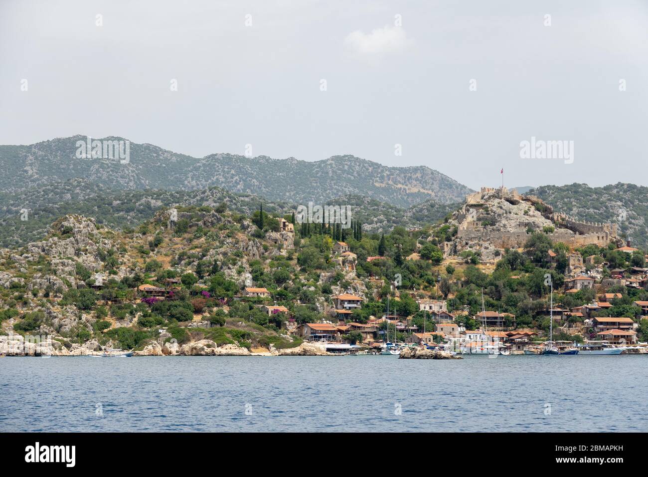 Kalekoy Dorf mit Steinhäusern und Burg auf dem Hügel in der Uchagiz Bucht in der Türkei in der Nähe versunkenen Stadt Kekova Stockfoto