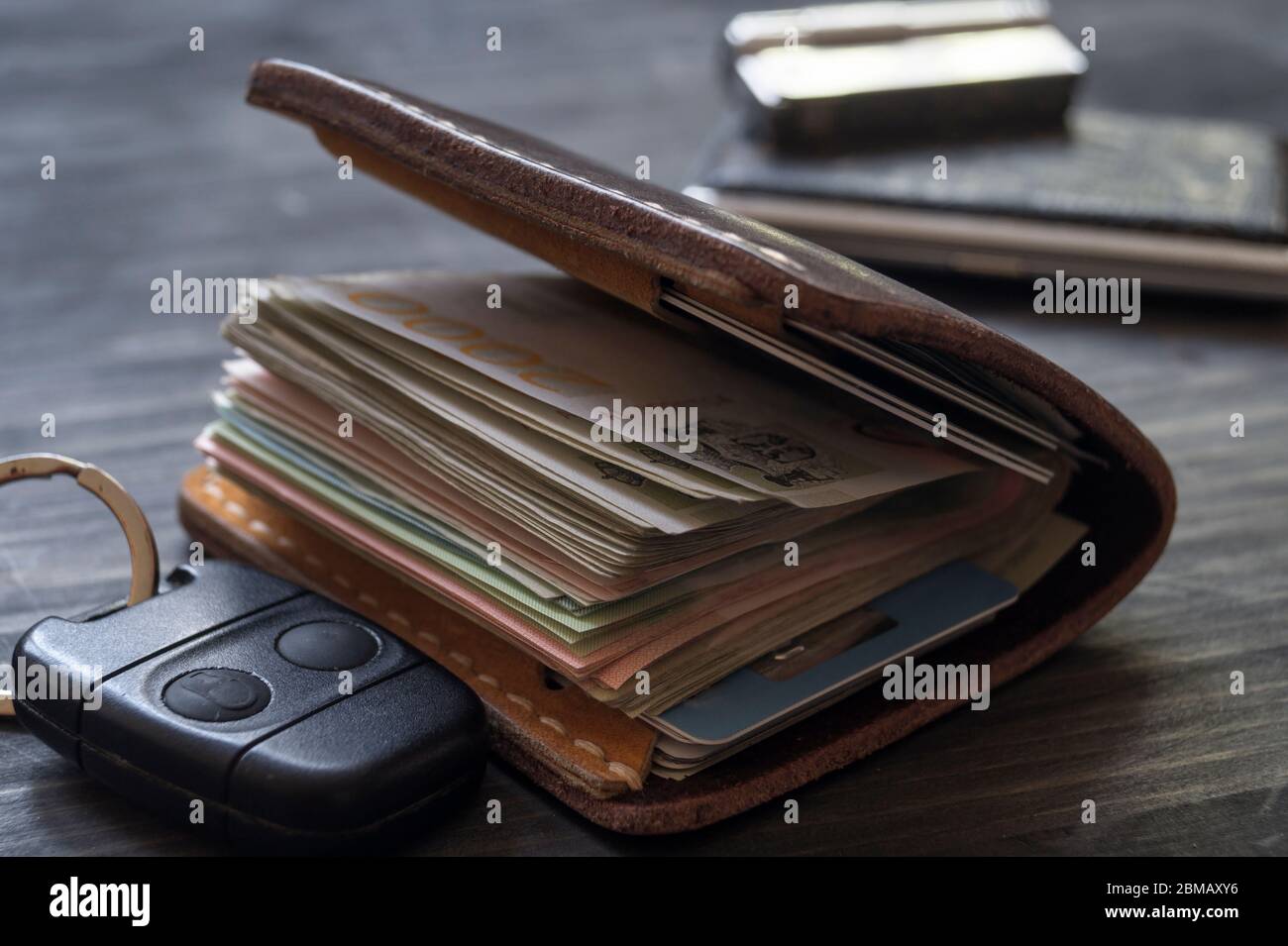Alte Lederbörse voller Geld auf Holzhintergrund, Nahaufnahme Stockfoto