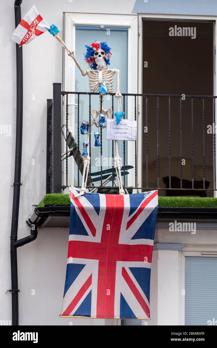 Southend on Sea, Essex, Großbritannien. Mai 2020. Die Strandpromenade bleibt trotz des warmen sonnigen Wetters während dieser besonderen Festtage während der COVID-19 Coronavirus Sperrzeit weitgehend ruhig. Einige Häuser am Meer haben ihre Fronten mit patriotischen Displays geschmückt, mit einem offensichtlichen COVID-19 Opfer mit Perücke und winken eine Flagge Stockfoto