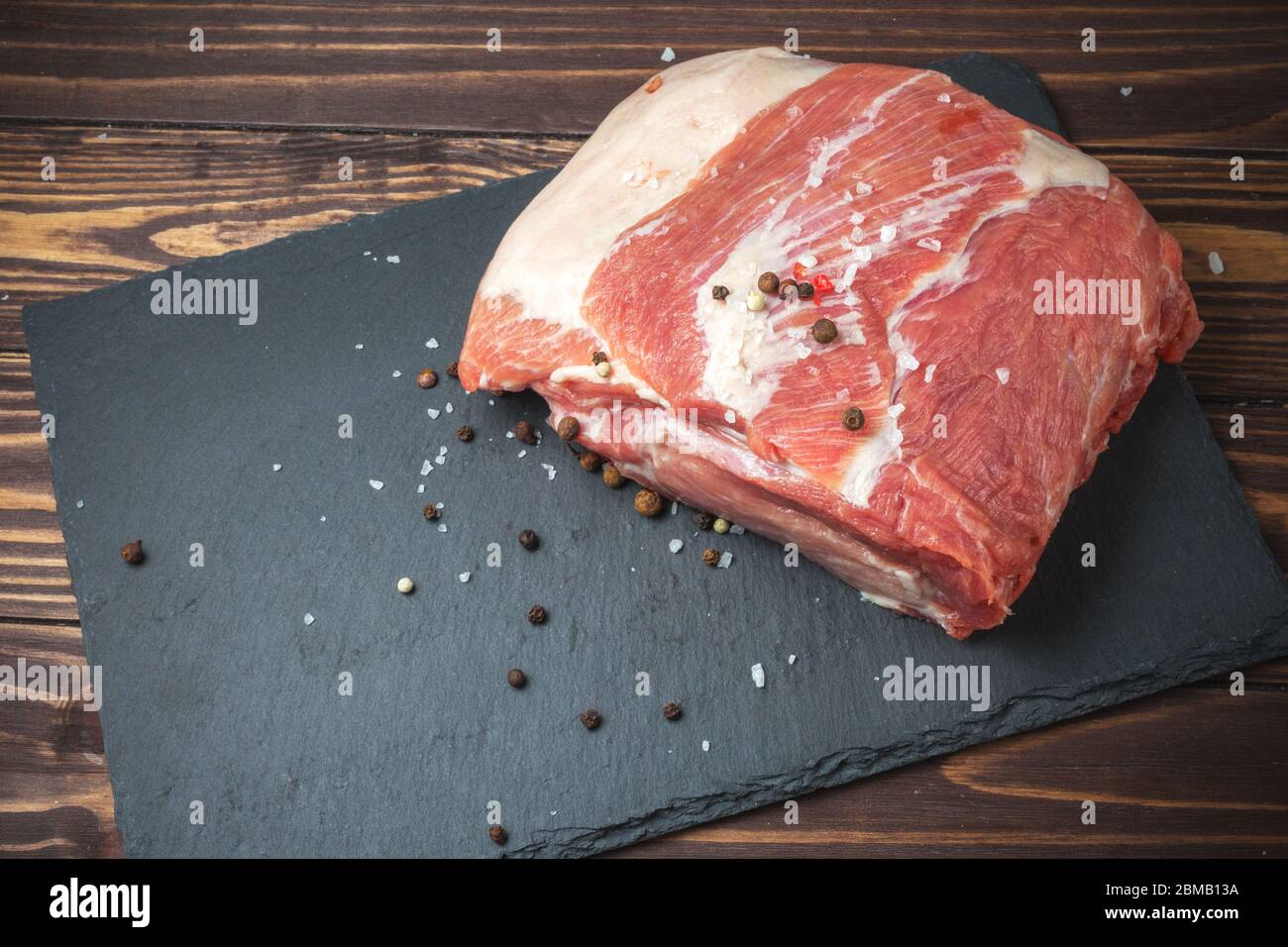 Rohes Schweinefleisch hacken Steak auf einem schwarzen Brett. Schweinehandrikot. Fleisch Stockfoto