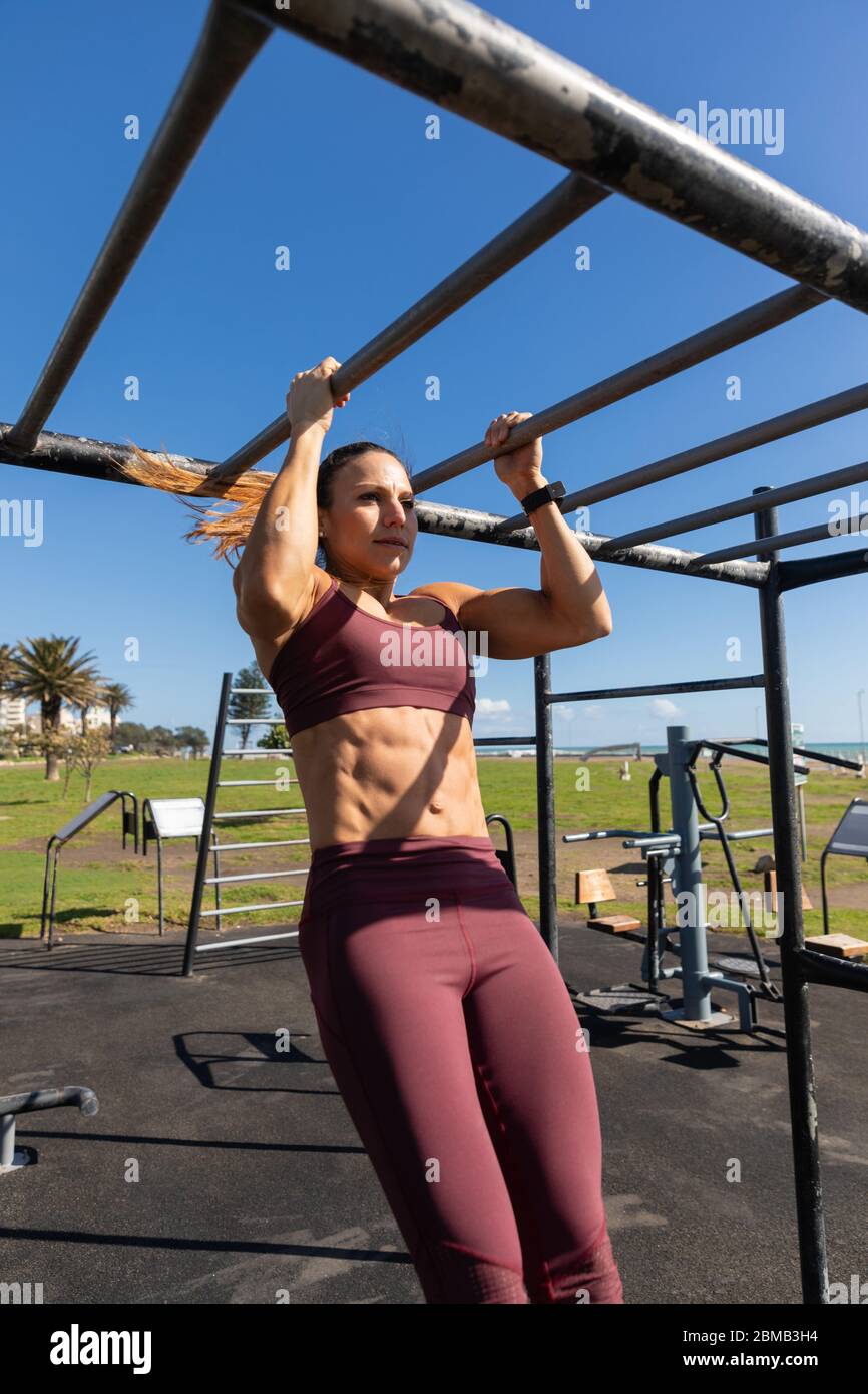 Sportliche kaukasische Frau Training auf dem Spielplatz Stockfoto