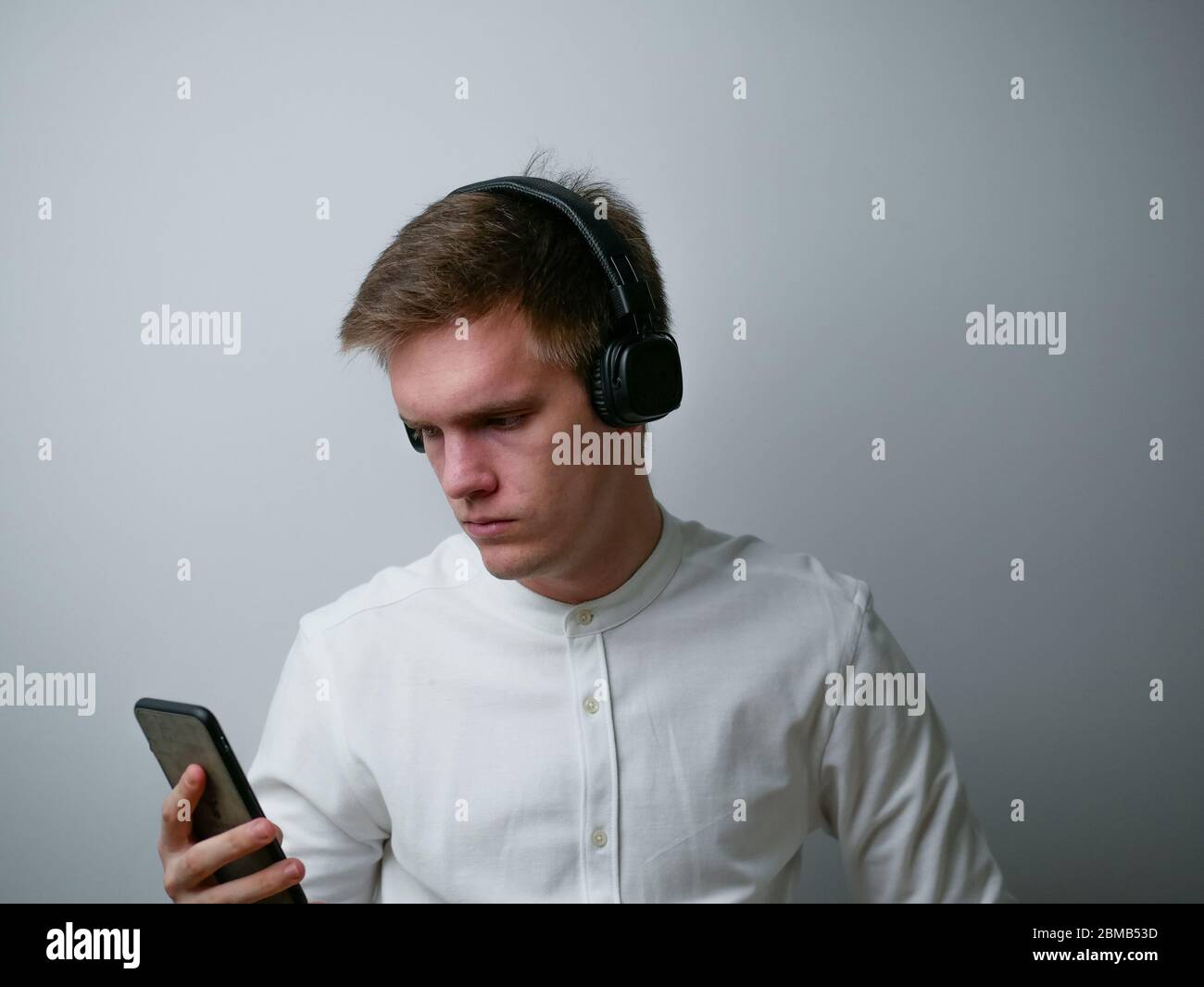 Nahaufnahme Porträt von jungen Mann trägt weißes Hemd hören Pop Rock Stereo-Sound Wochenende isoliert auf weißem Hintergrund. Stockfoto