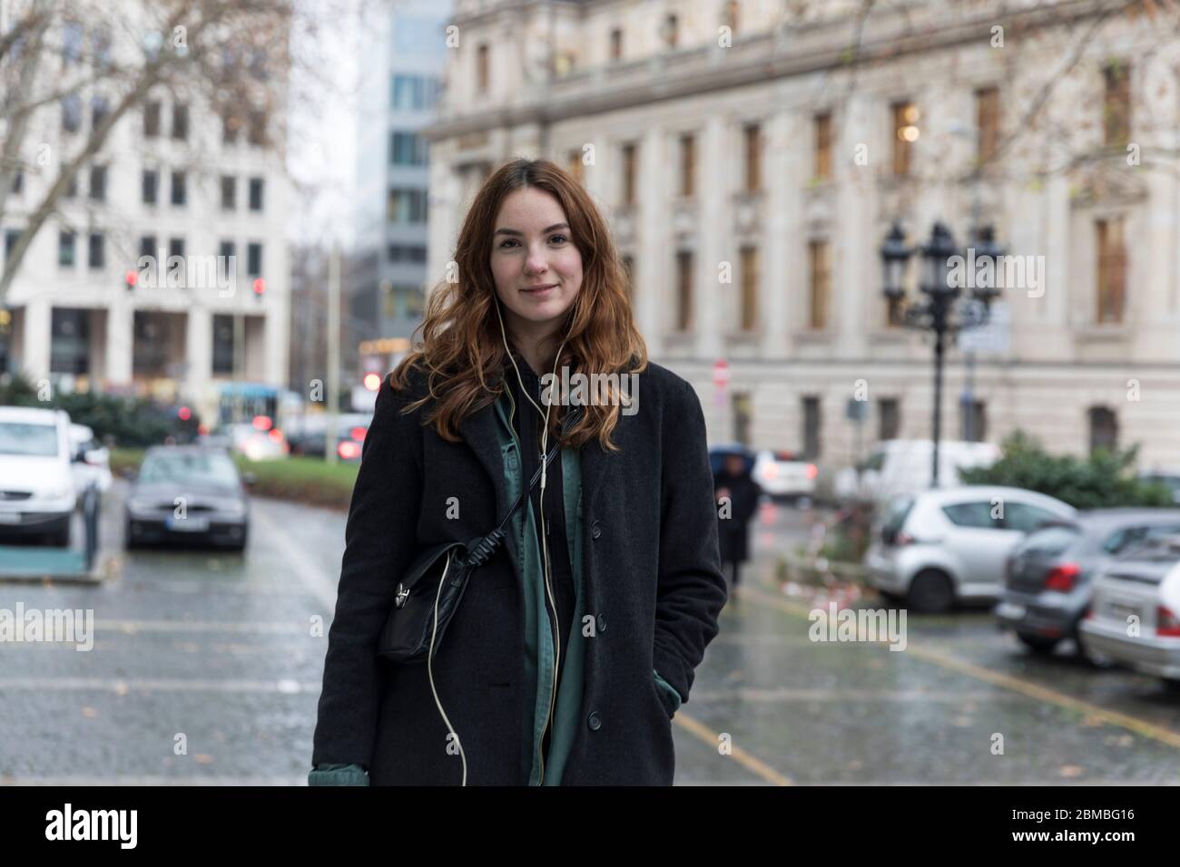 Junge Urbanite Frau mit echtem Lächeln posiert in der Stadt Stockfoto