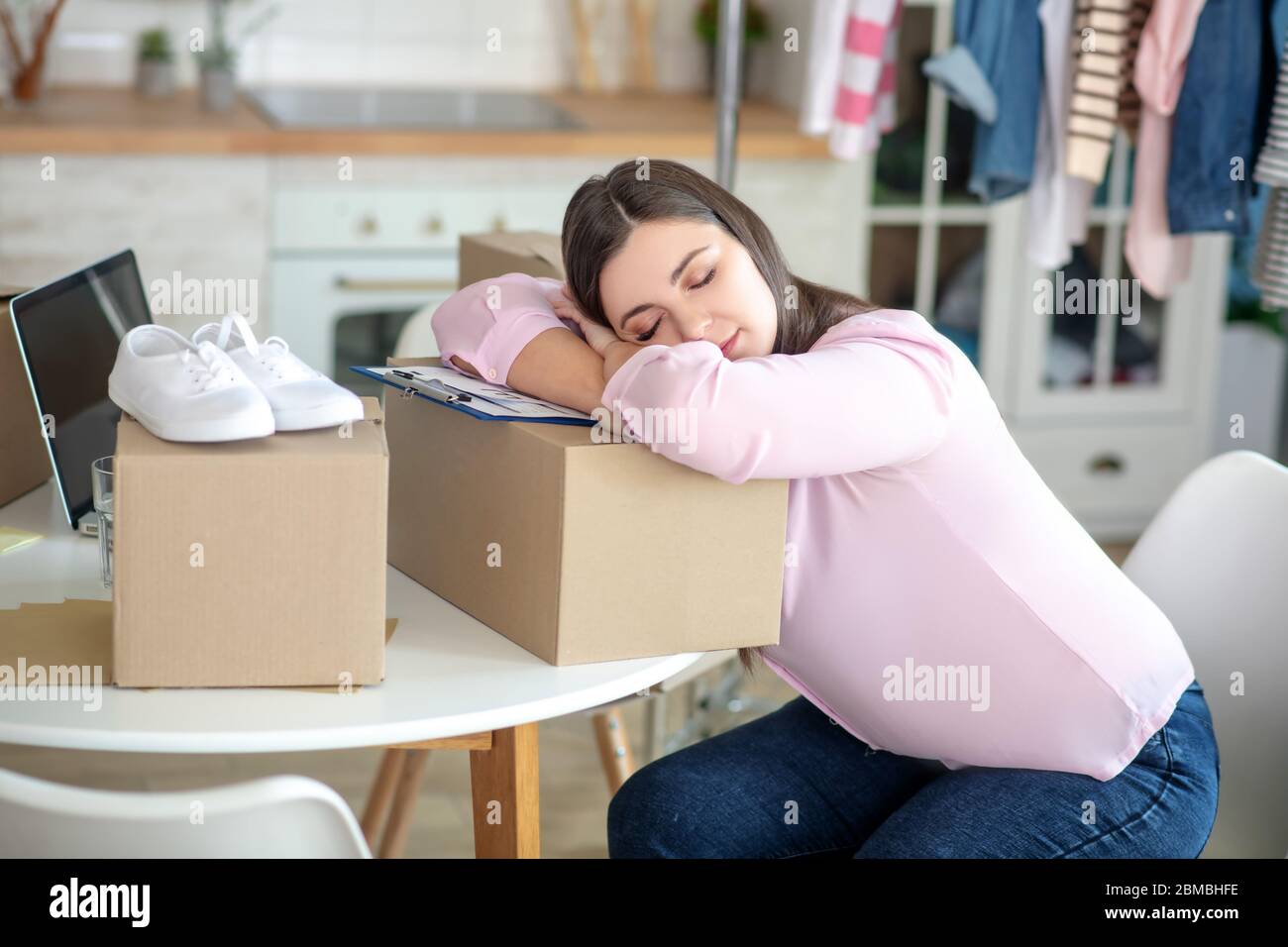 Dunkelhaarige junge Frau schläft auf den Boxen Stockfoto