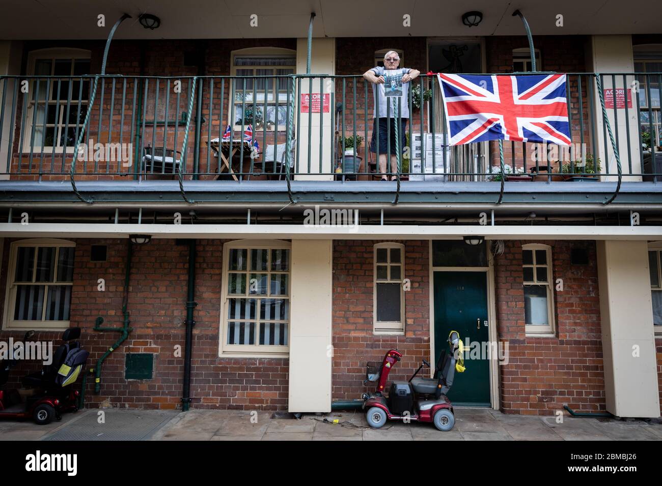 Manchester, Großbritannien. Mai 2020. Terry, der in Victoria Square wohnt, hält ein Bild seines verstorbenen Freundes. Trevor Jones, der für die Entwicklung der Gärten verantwortlich war, in denen die Bewohner den diesjährigen VE Day feiern werden, ist letzten Monat leider verstorben. Heute jährt sich das Ende des Zweiten Weltkriegs zum 75. Mal, als Großbritannien und seine Verbündeten Nazi-Deutschland besiegten. Aufgrund der COVID-19 mussten die Feierlichkeiten dieses Jahr an soziale Distanzierungsmaßnahmen zum Schutz der Bevölkerung nach Todesfällen im Landkreis auf über 30000 angestiegen sein. Kredit: Andy Barton/Alamy Live News Stockfoto