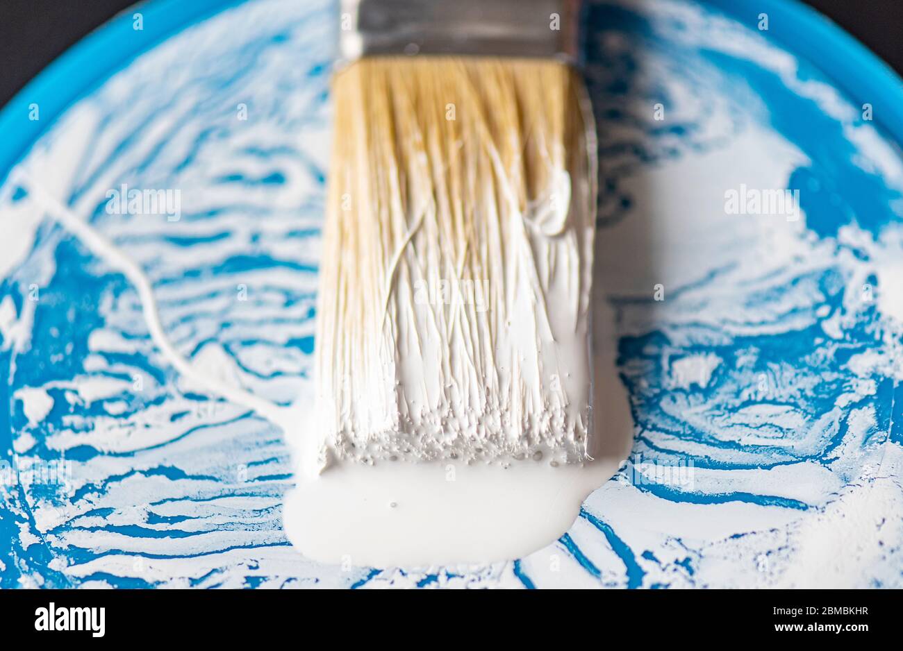 Nahbemalung Pinsel oder Pinsel mit weißer Farbe auf der Oberfläche der Borsten und blauen Zinn, Dose Stockfoto