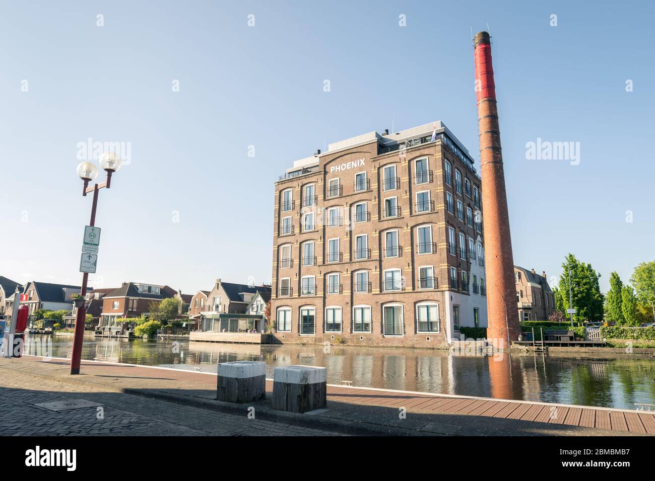 Alte Fabrik mit Schornstein am Rhein entlang. Heute wurde es in ein Mehrfamilienhaus umgewandelt. Stockfoto
