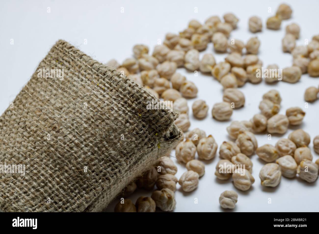 Kichererbsen verschüttet in der Sackleinen auf weißem Hintergrund Stockfoto