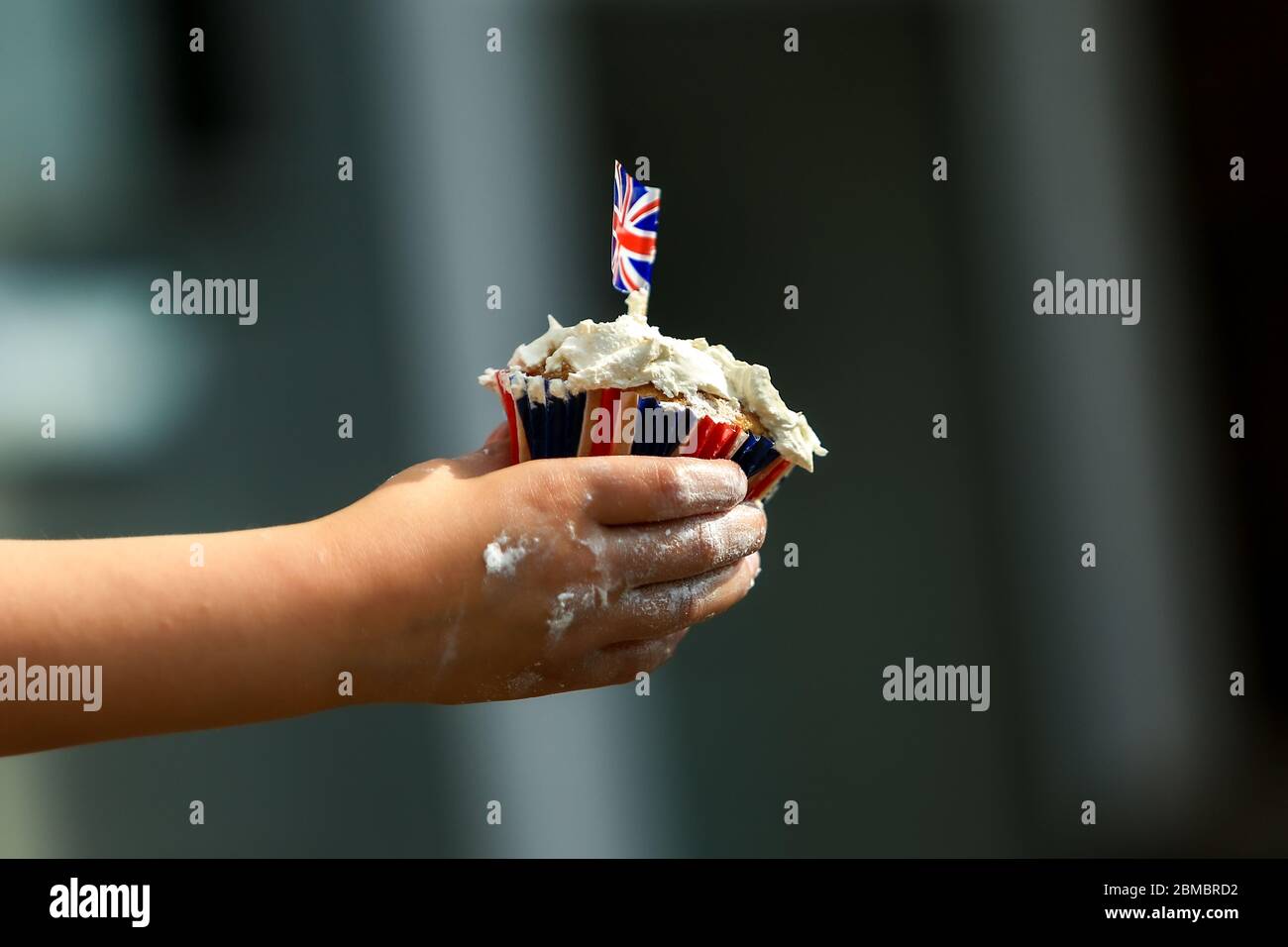 Halesowen, West Midlands, Großbritannien. Mai 2020. Ein Kind hält einen Kuchen mit VE Day 75-Thema. Quelle: Peter Lopeman/Alamy Live News Stockfoto