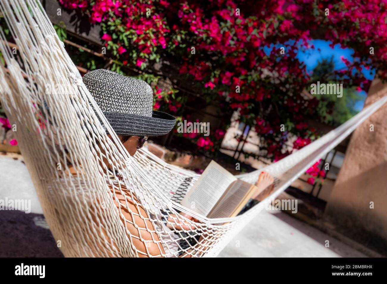 Eine Frau entspannt sich vor ihrem Zimmer in Hacienda Sepulveda, Lagos de Moreno, Jalisco, Mexiko. Stockfoto