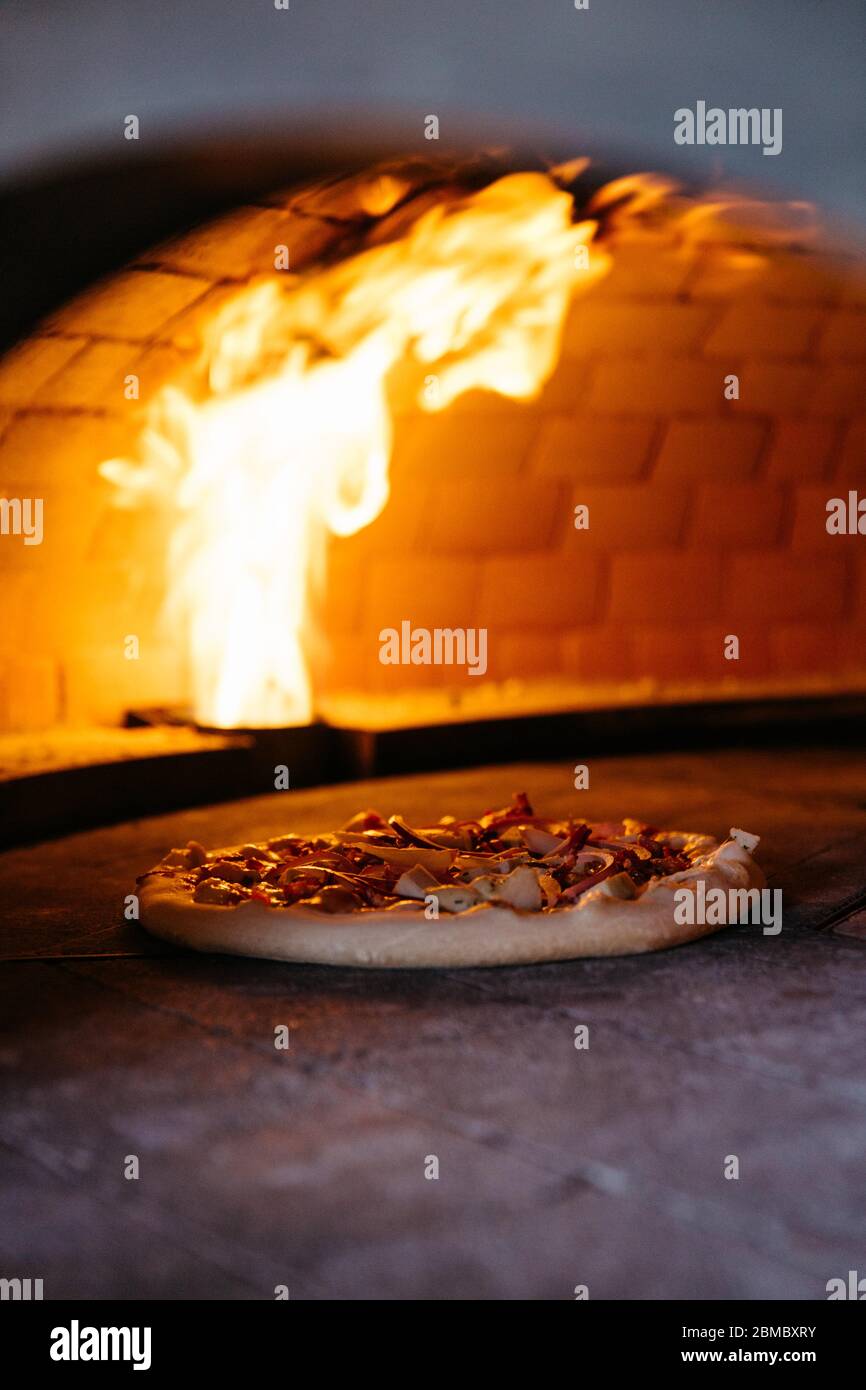 Handgemachte Pizza im Holzfeuerofen Stockfoto