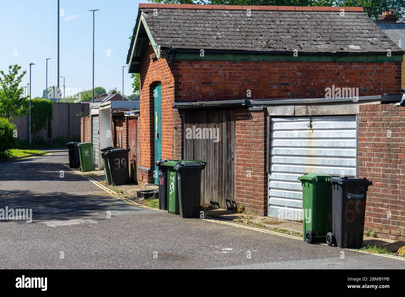 Eine Hinterstraße in England mit Mülltonnen auf der Straße Stockfoto