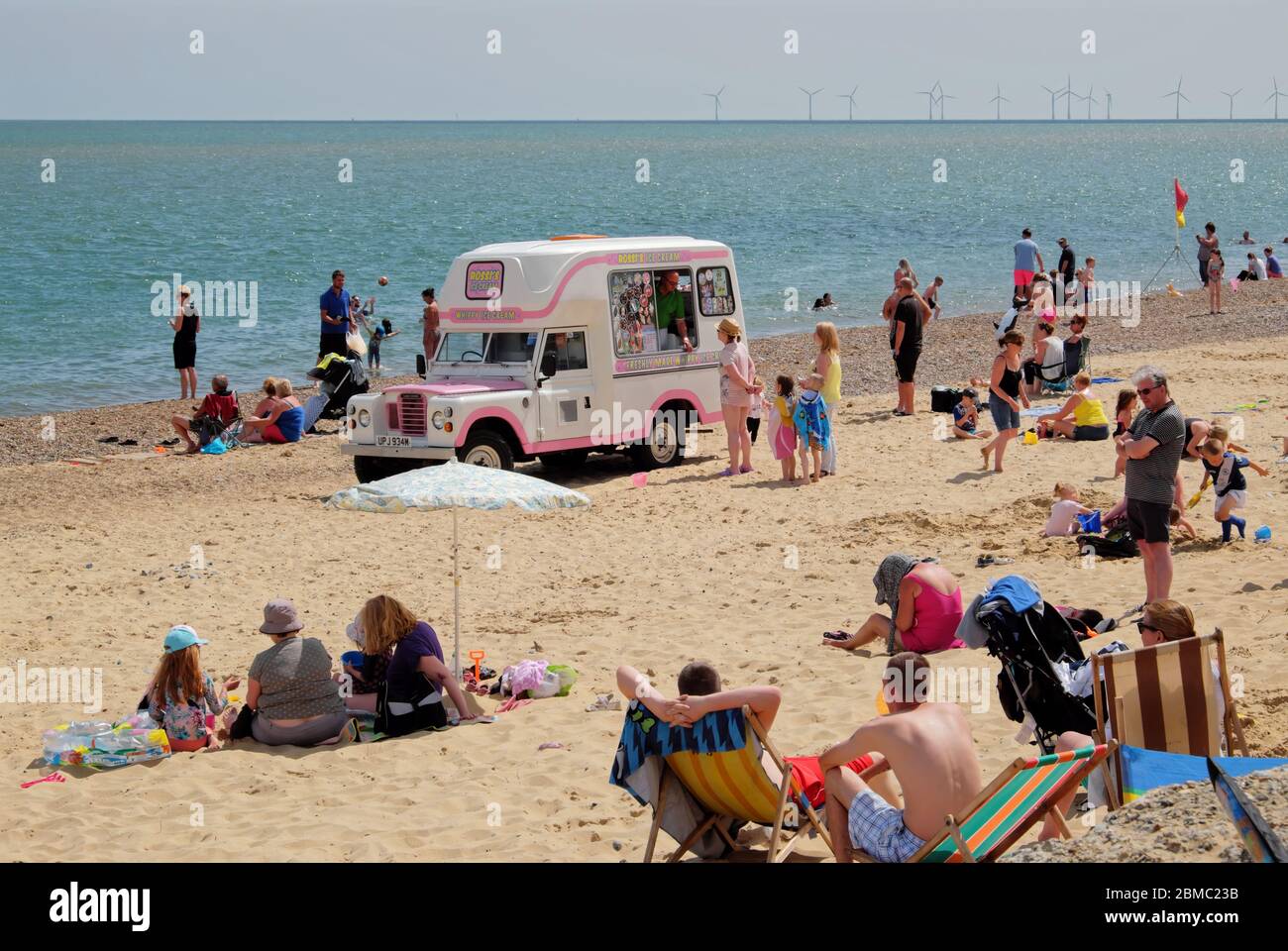 Urlauber genießen einen Tag am Hemsby Strand. Hemsby, Great Yarmouth NR12 9BX Stockfoto