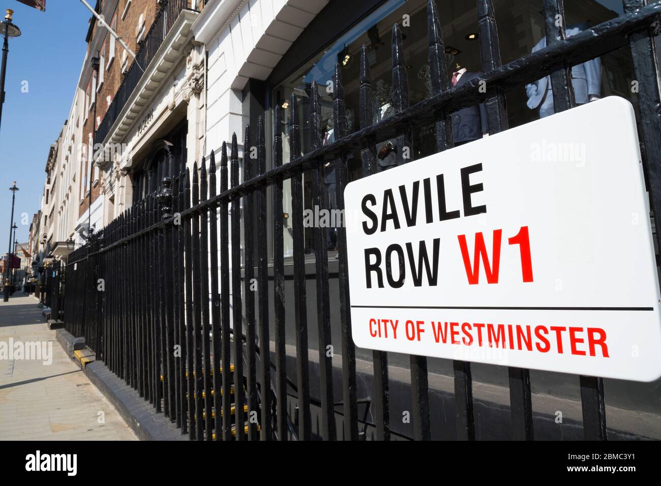 Westminster Straßenschild an der Savile Row in London, die Goldene Meile der Maßanfertigung, ist an den Geländern von Gieves und Hawkes angebracht - Herren Schneider / Schneiderei vor und Fenster Display. GROSSBRITANNIEN (118) Stockfoto