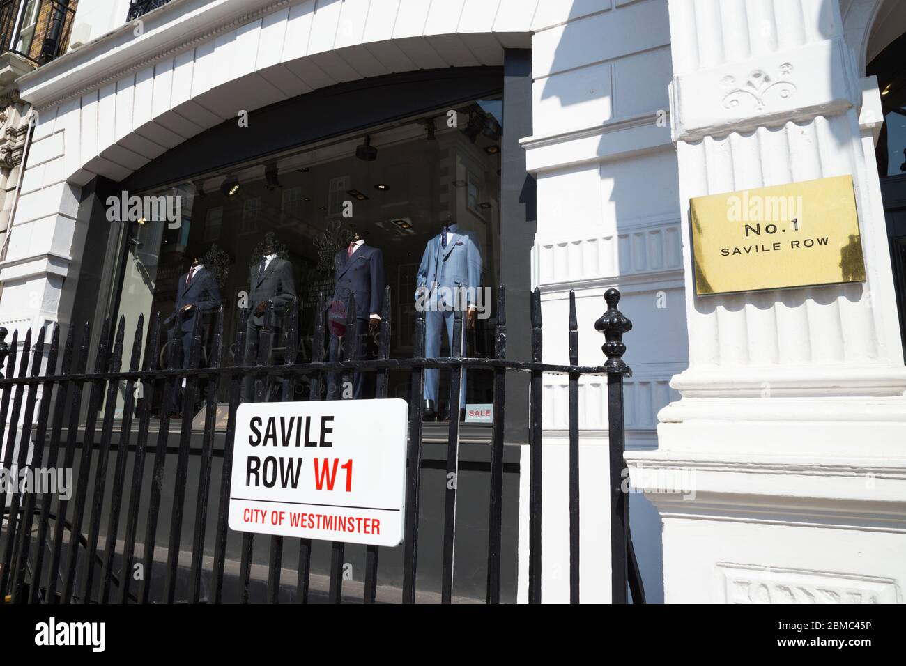 Gieves & Hawkes - Herrenschneiderei / Schneiderei vorne und Schaufenster in Nummer 1, Savile Row, London, Großbritannien. Das Straßenschild Westminster ist an den Geländern angebracht. (118) Stockfoto