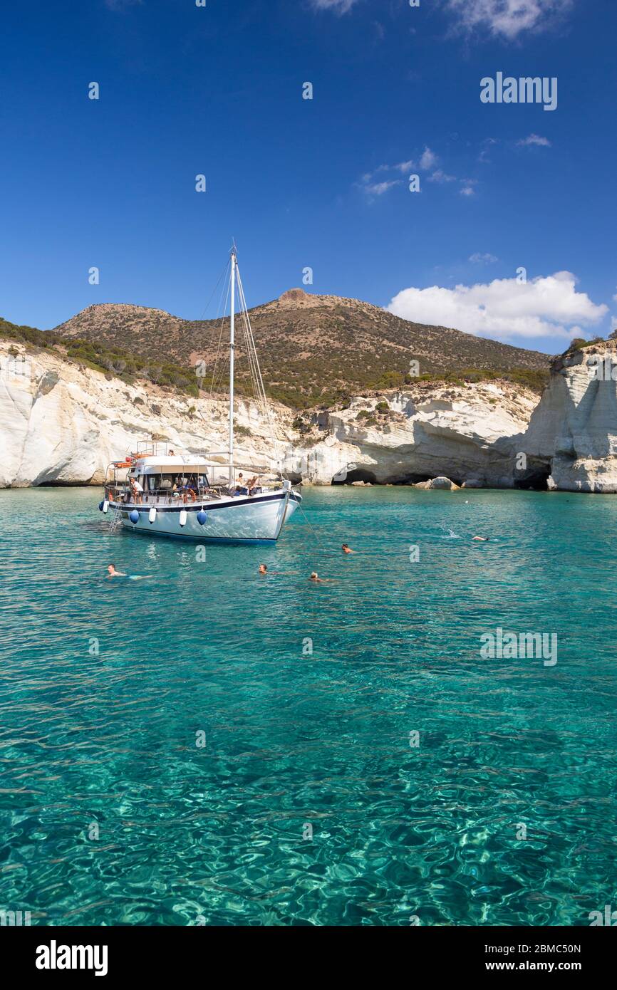 Ein Boot und Menschen schwimmen in Kleftiko, Milos, Kykladen Inseln, Griechenland Stockfoto