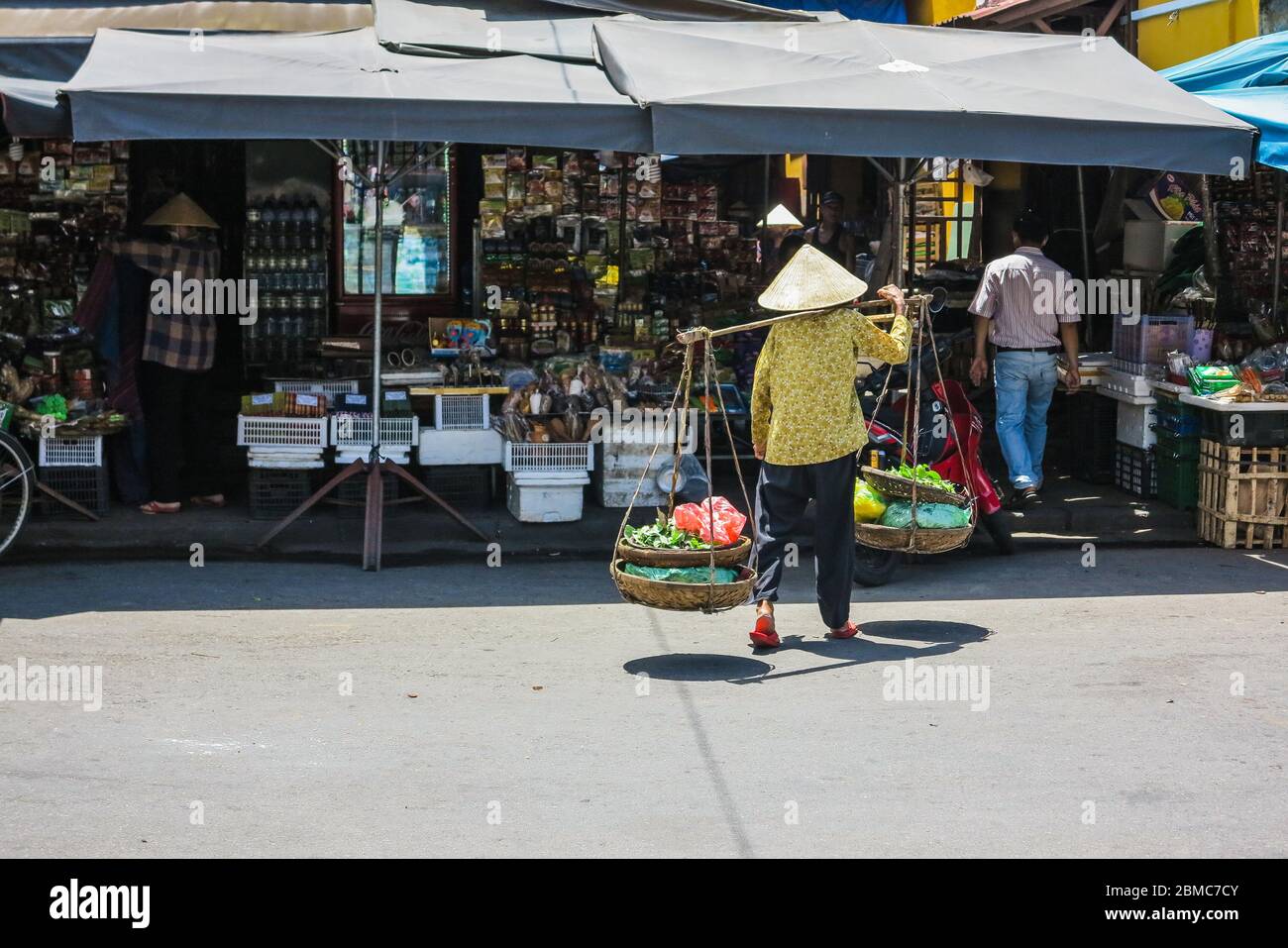 Frau trägt Körbe mit Gemüse mit Bambus-Tragehägel Stockfoto