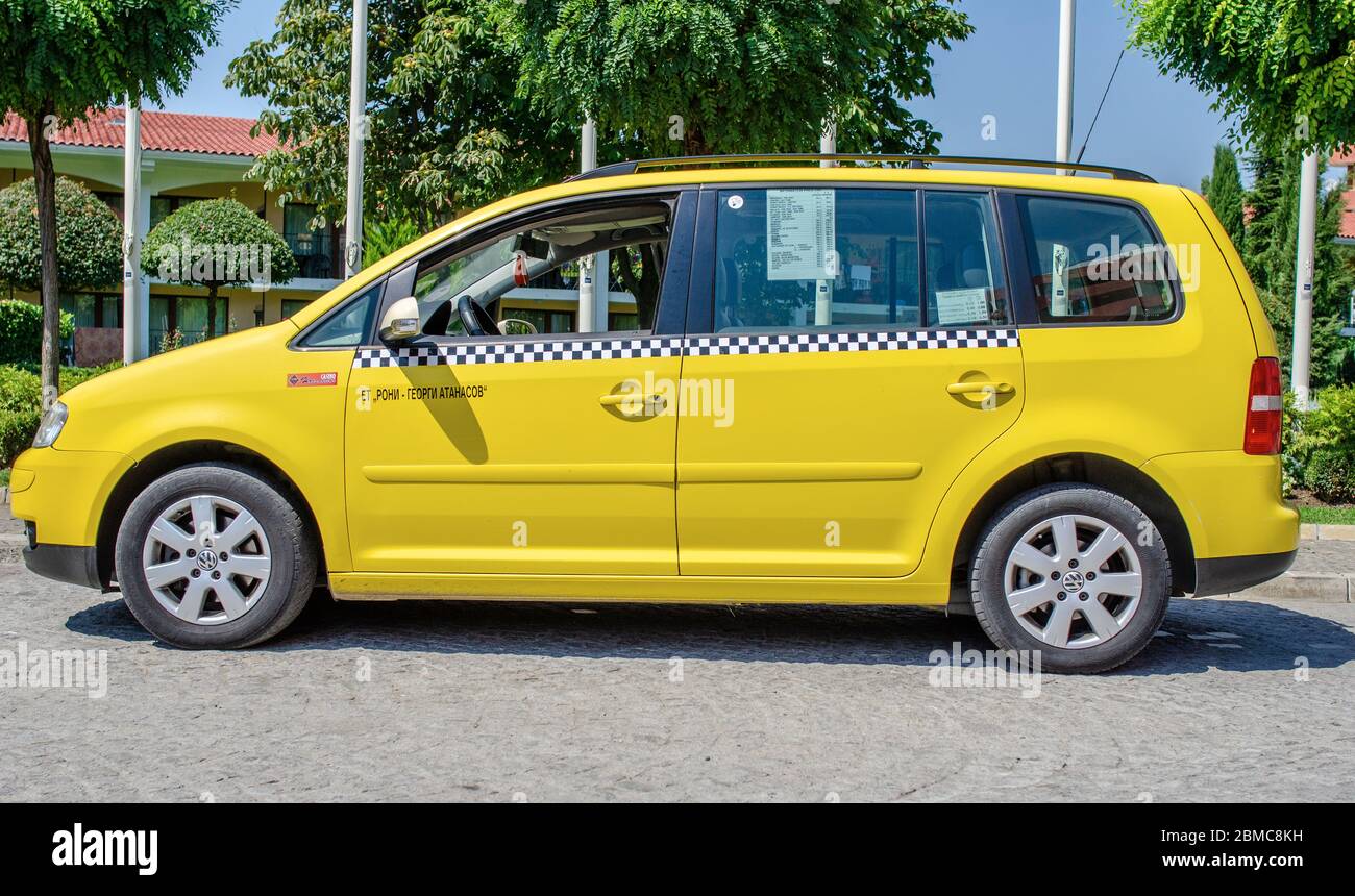 Gelbes Taxi auf einem Parkplatz auf einer Stadtstraße in Nessebar, Bulgarien. Stockfoto