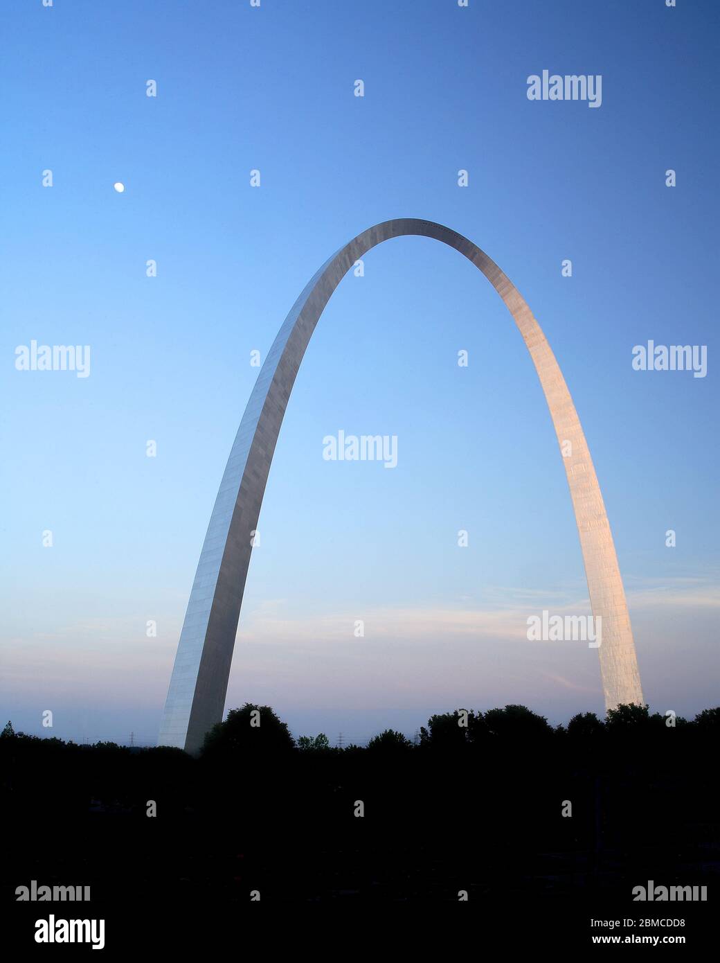 Der Gateway Arch in St. Louis bei Sonnenuntergang zeigt den Mond, der in der Abenddämmerung aufgeht, während das letzte Licht des Tages vom Edelstahldenkmal reflektiert wird. Stockfoto