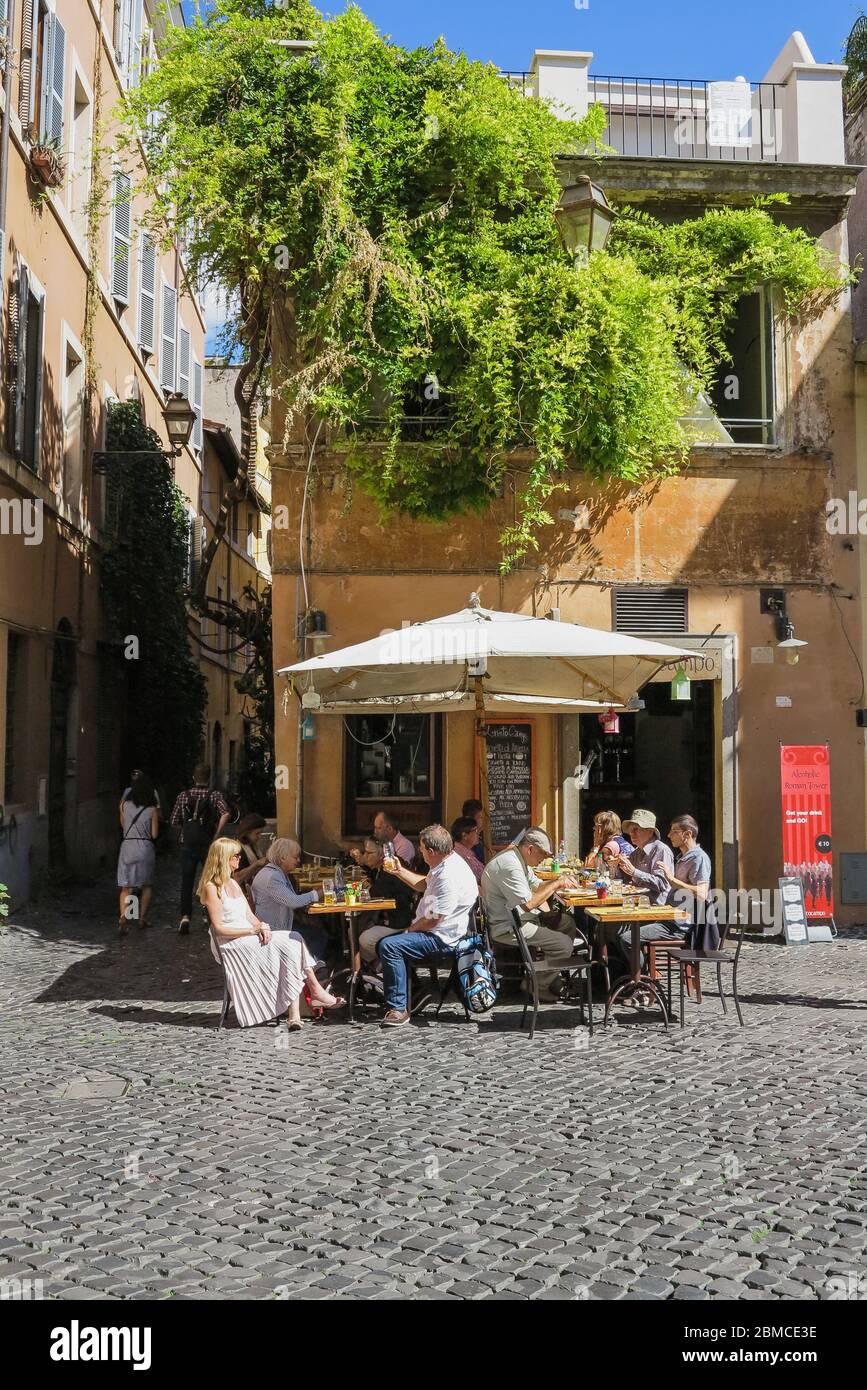 Touristen essen Mittagessen im Freien in der charmanten Nachbarschaft Trastevere, in Rom, Italien Stockfoto