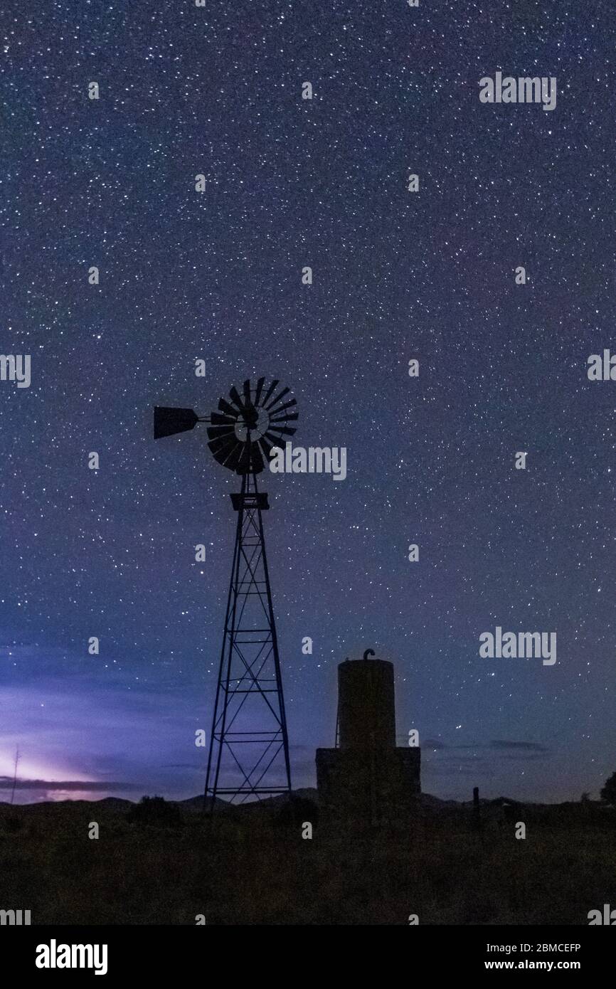 Windmühle gegen den riesigen Sternenhimmel über dem City of Rocks State Park, zwischen Silver City und Deming in der Chihuahuan Wüste, New Mexico, USA Stockfoto