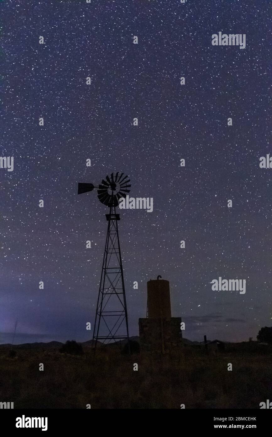Windmühle gegen den riesigen Sternenhimmel über dem City of Rocks State Park, zwischen Silver City und Deming in der Chihuahuan Wüste, New Mexico, USA Stockfoto