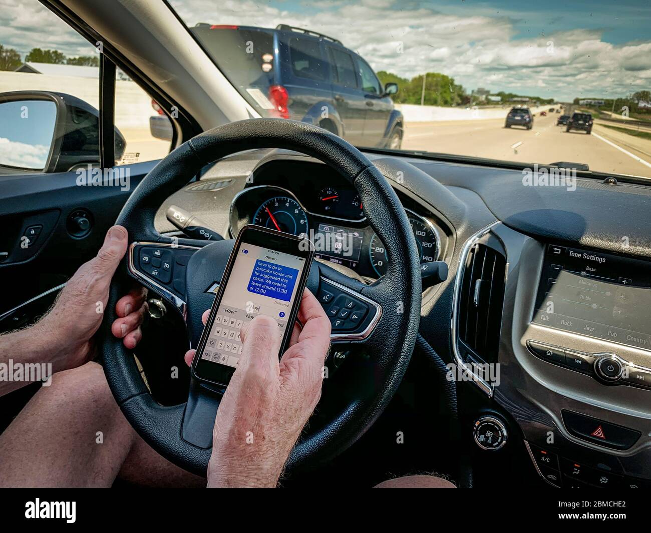 Textnachrichten und Fahrten auf der Autobahn tagsüber Stockfoto