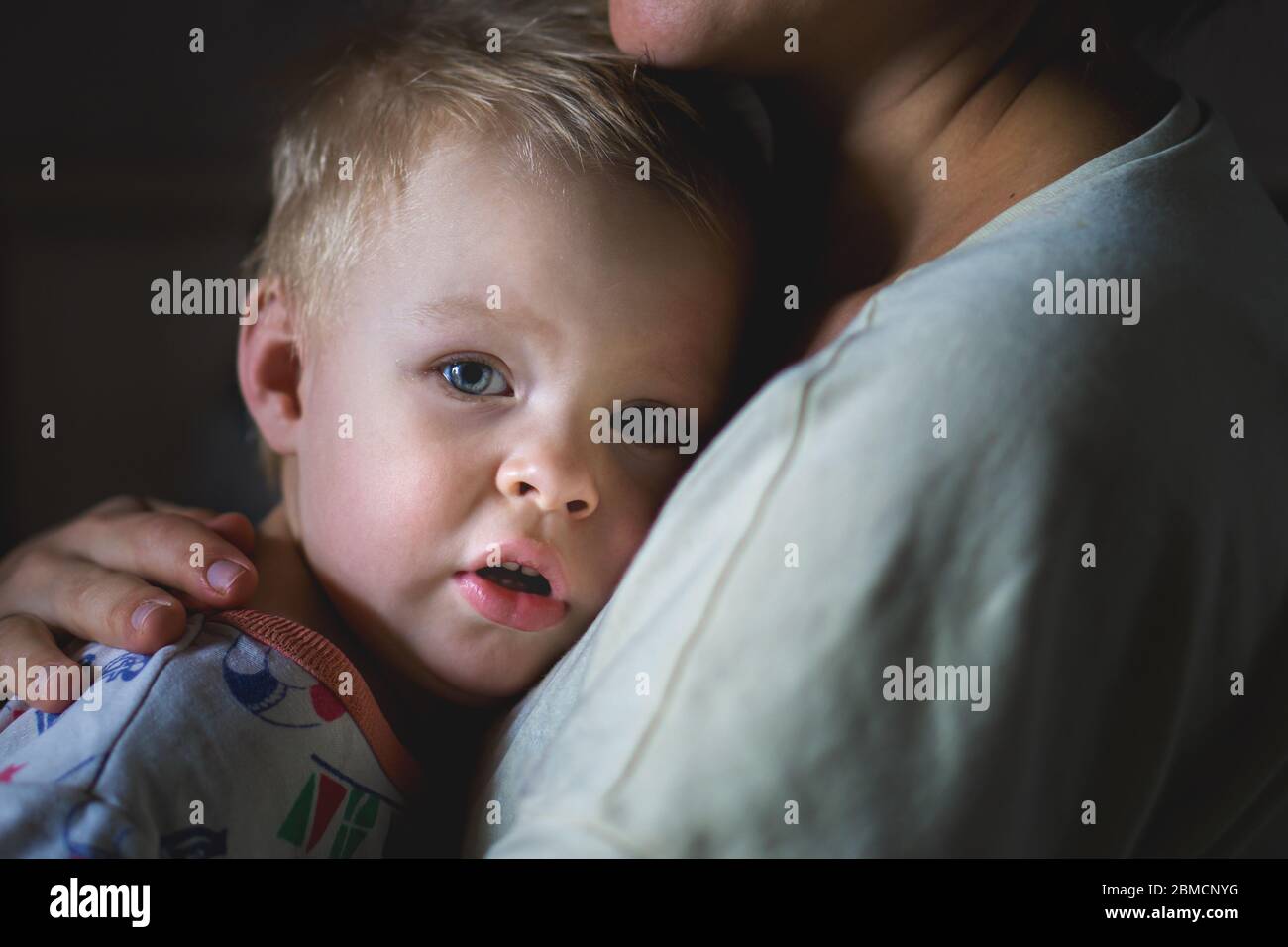 Ein tränenvoller kleiner Junge klammert sich an seine Mutter, um sich zu beruhigen. Die Sorge und das Sorgerecht einer Mutter. Die Beziehung zwischen Eltern und Kindern Stockfoto