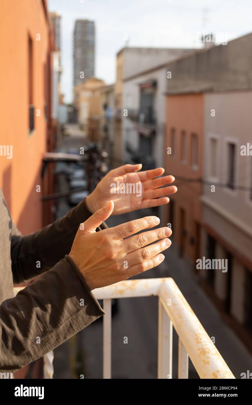 Frau applaudiert auf einem Balkon von Spanien Gruß für die Arbeit von Ärzten, Krankenschwestern, Politik während der Coronavirus-Epidemie Stockfoto