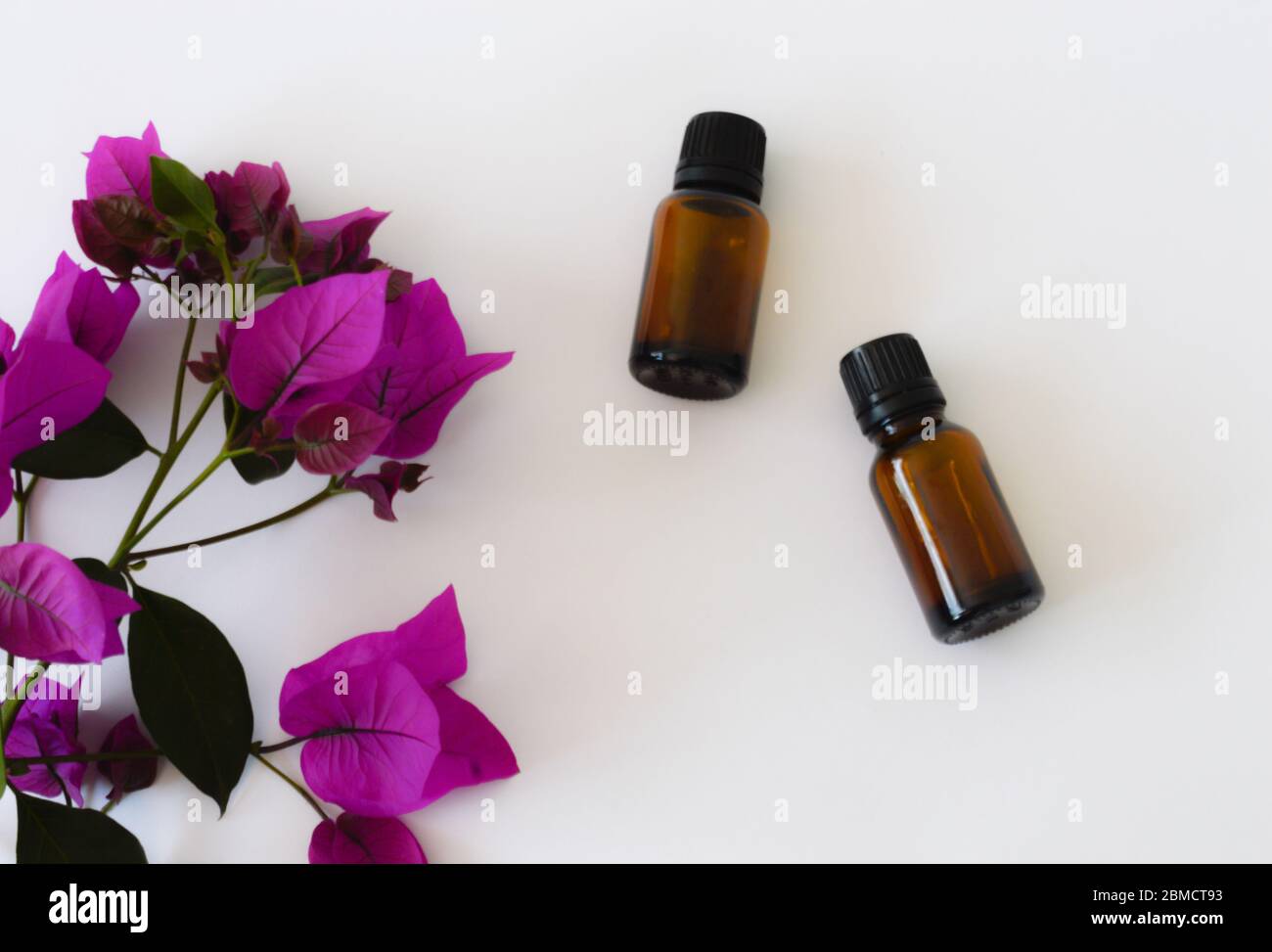 Zwei Flaschen ätherisches Öl mit violetten Blüten Stockfoto