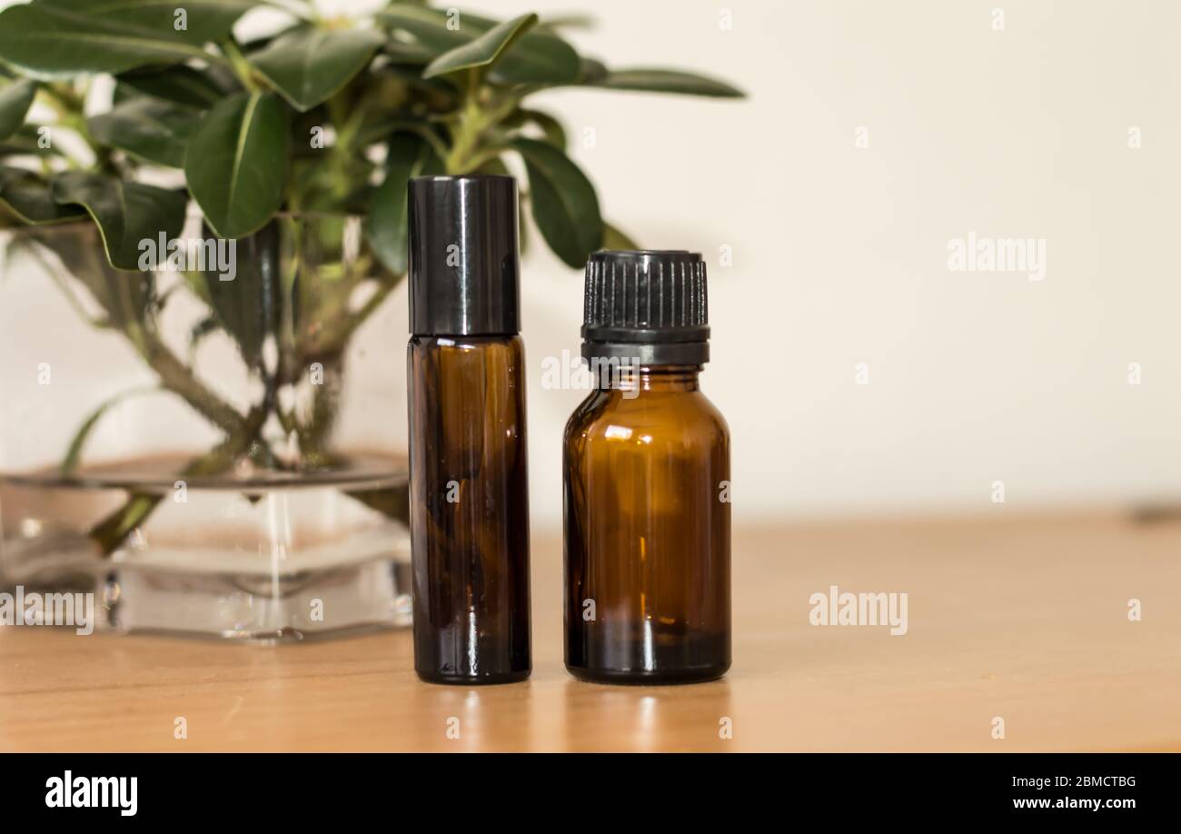 Zwei Flaschen natürliche ätherische Öle auf Holztisch Stockfoto