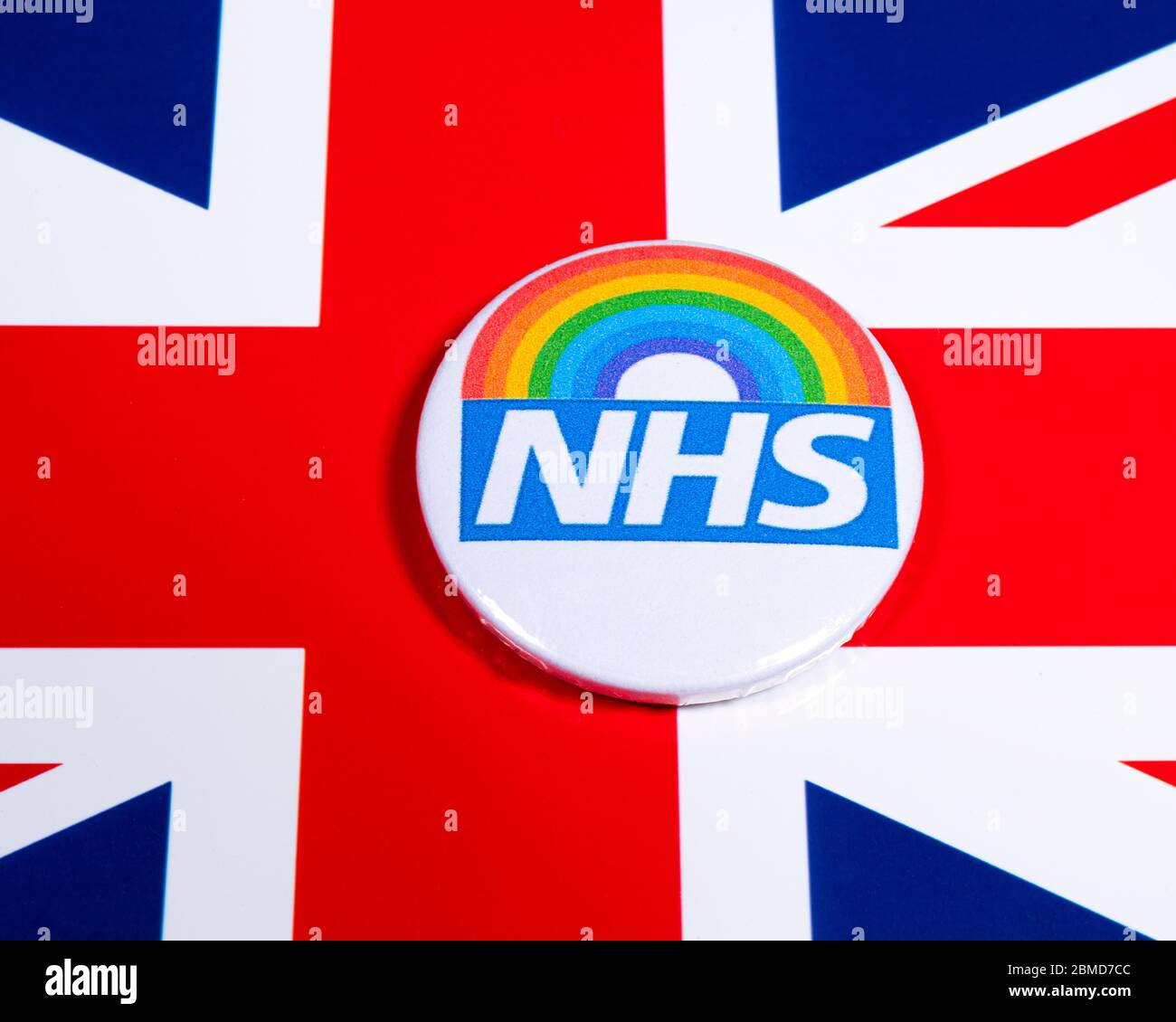 London, Großbritannien - 5. Mai 2020: Ein Pin-Abzeichen mit dem Symbol des National Health Service und Regenbogen, abgebildet über der britischen Flagge. Stockfoto