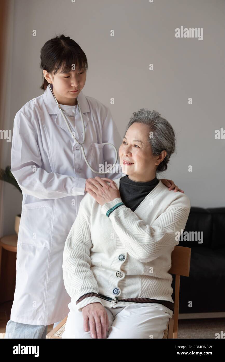 Der junge Hausarzt spricht mit Senioren Stockfoto